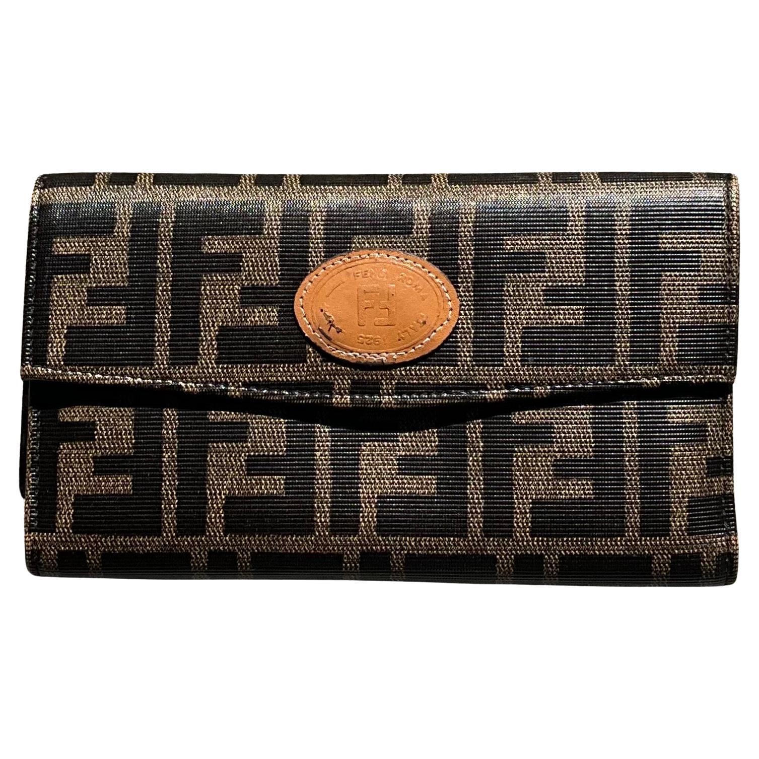 This Vintage Fendi Trifold Canvas Leather Wallet typically represents a blend of luxury and functionality, combining the craftsmanship of Fendi with timeless style. 

The exterior is a mix of canvas (often featuring the iconic FF logo print, which
