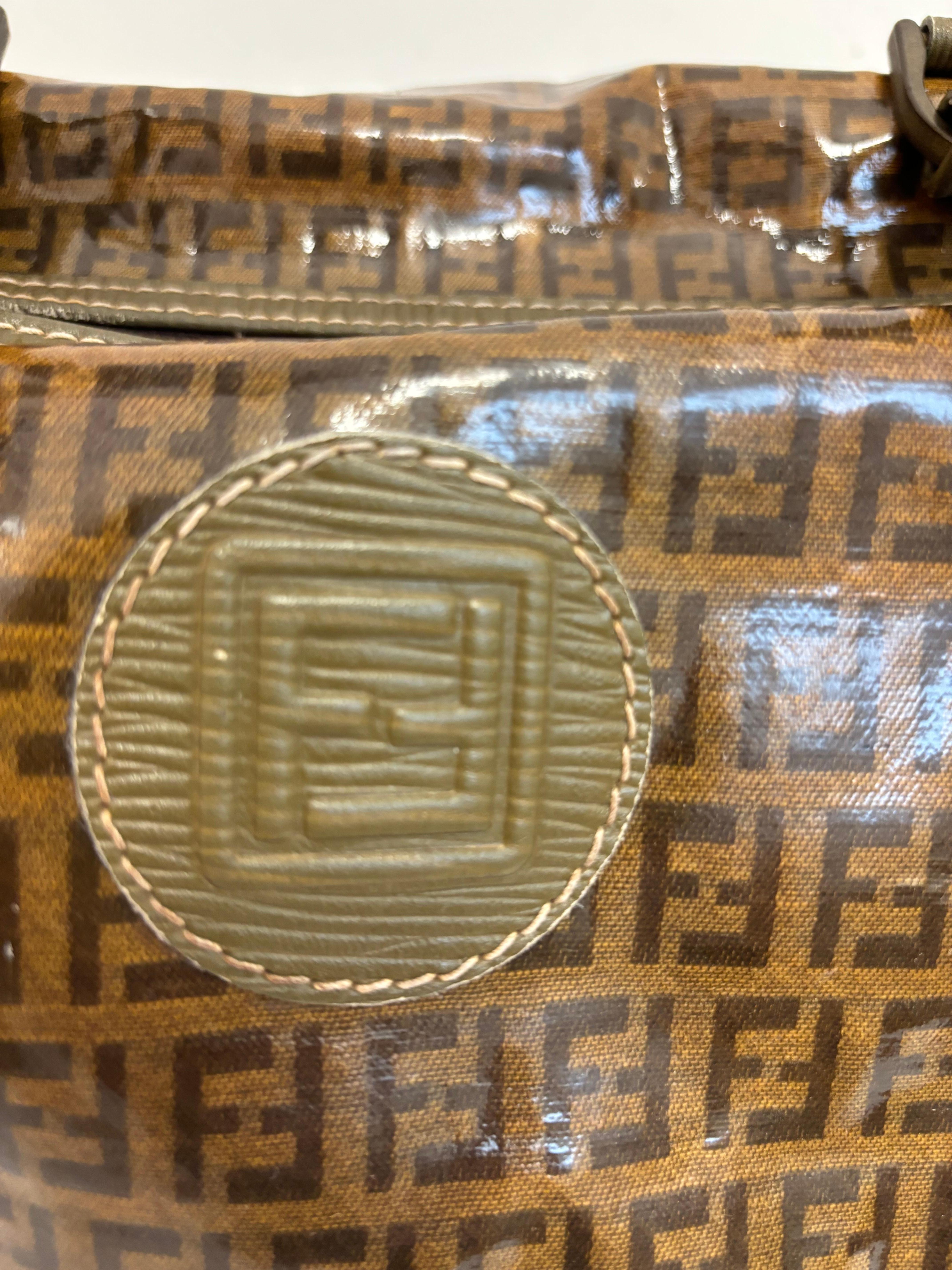 This Fendi Zucca Boston bag is roomy and made of coated canvas with leather trim. The bag has a top zip closure for easy access. There is a key/lock on the zipper which acts as the pull.
The interior has a zip pocket for security.
There is a little