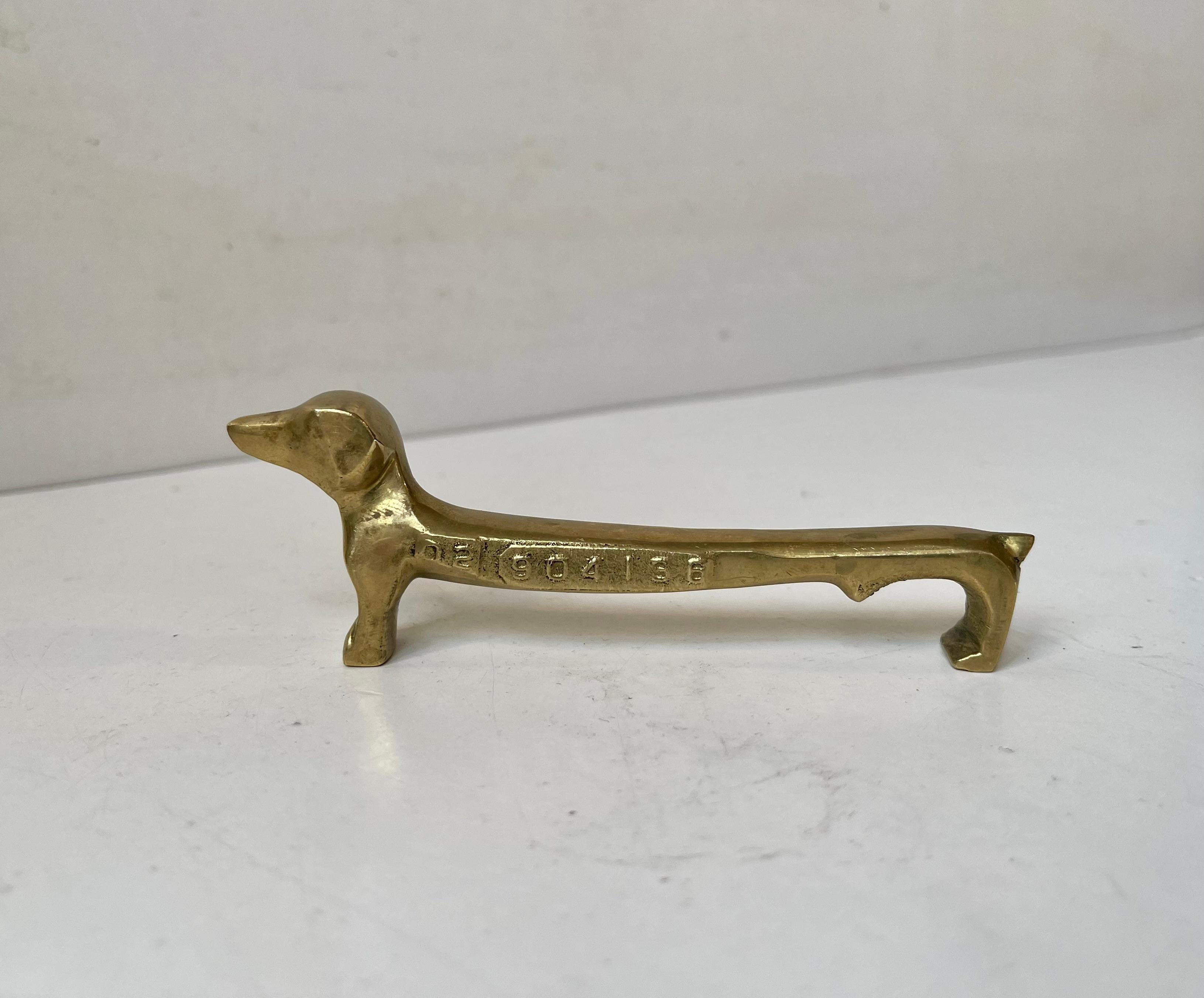 Elongated and exaggerated dachshund bottle cap opener in solid brass. It is called Feni and has its own serial number. Reminiscent in style to similar pieces from Wiener Werkstätte and Walter Bosse in particular.   

Measurements: L: 12 cm, H: 4 cm,
