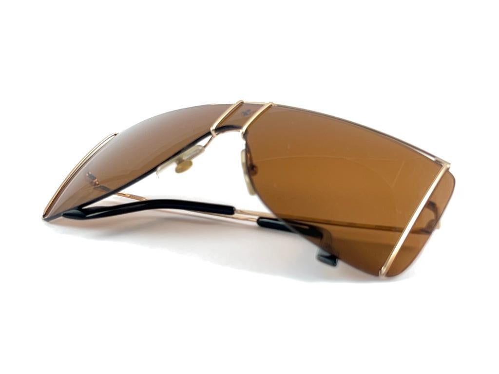 Vintage Ferrari F20 Sunglasses gold accents frame.

This item have minor sign of wear on the lens, no structural damage or repairs.

Made in Italy.

Front : 13 cms 

Lens Width : 13 cms

Lens Height : 5.5 cms
