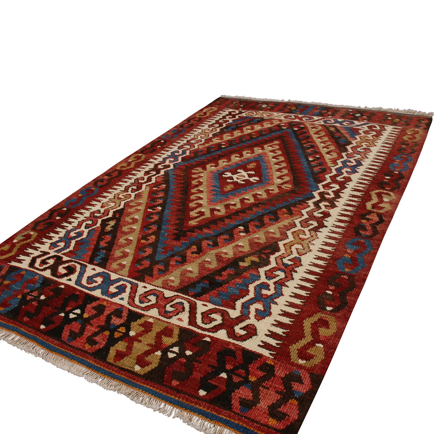 Flat-woven in high-quality wool originating from Turkey between 1940-1950, this vintage Fetiye wool Kilim rug enjoys a unique innermost beige-brown border, lending dimensionality to the rich and muted burgundy, navy blue, black, green, and orange