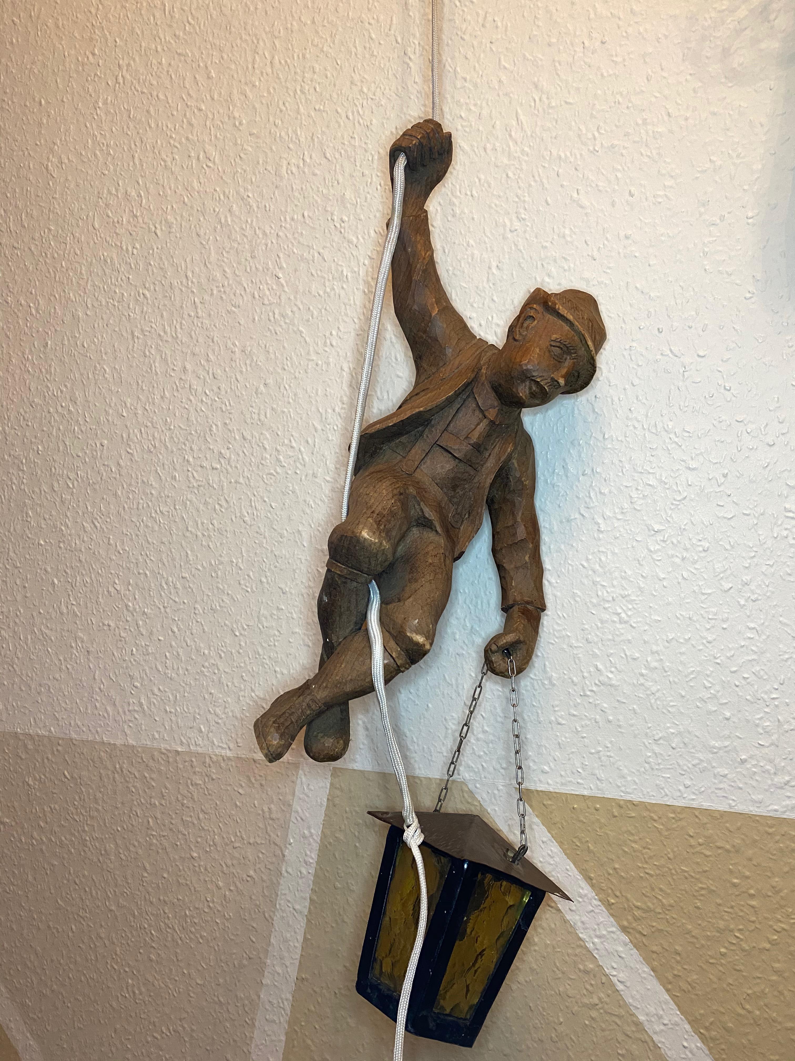 Stunning very rare hand carved Black Forest style wood mountain climber lantern or ceiling light. Pendant lamp off a mountain climber hanging from a rope with a lantern in his hand. Carved Figure is approx. 16