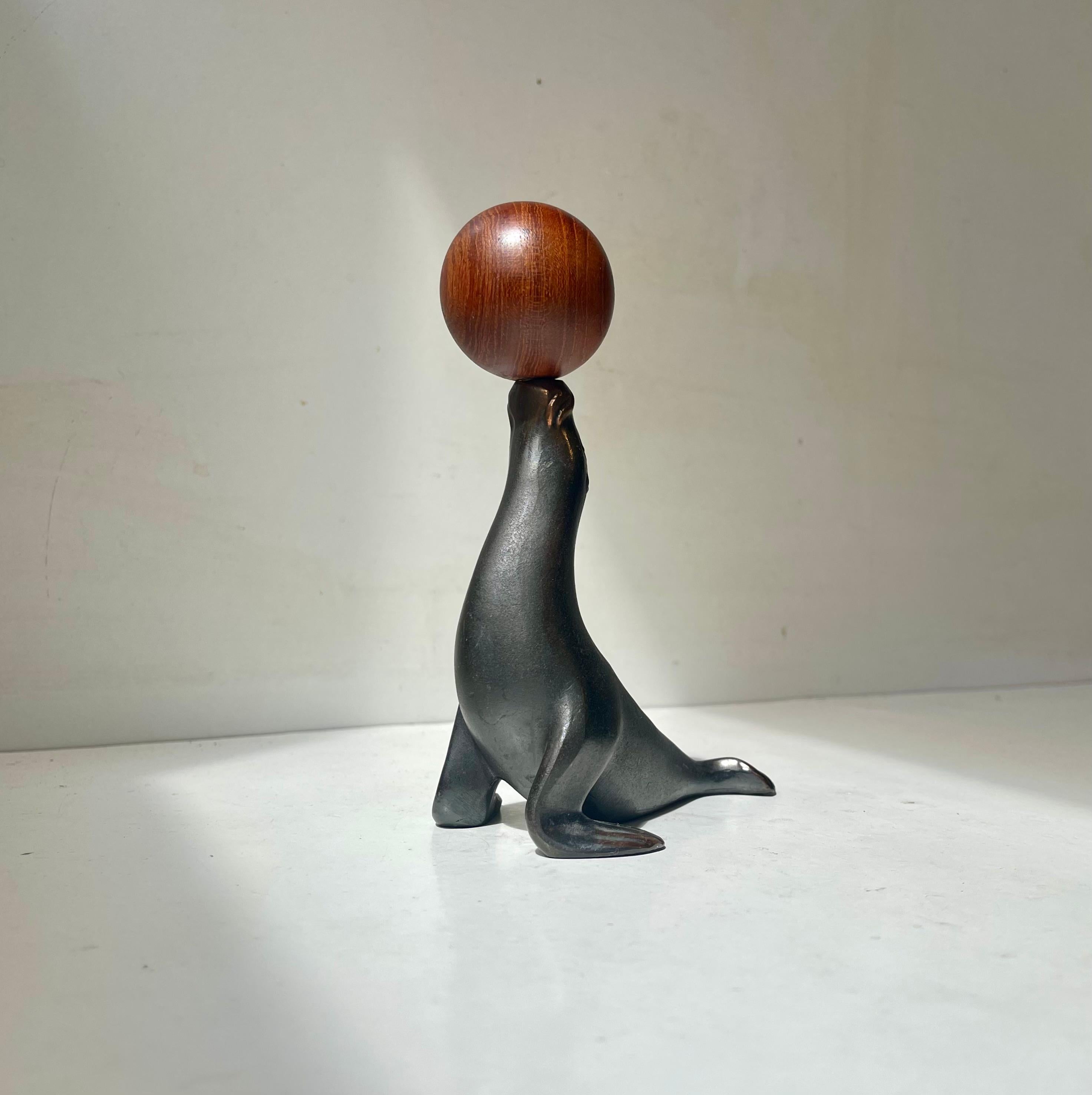 Insolito leone marino o foca di ispirazione Wiener Werkstätte che bilancia un cavatappi con manico sferico in teak. Il sigillo è in rame patinato ed è stato realizzato da Zero a Copenaghen in Danimarca negli anni '50 o forse un po' prima. Questo