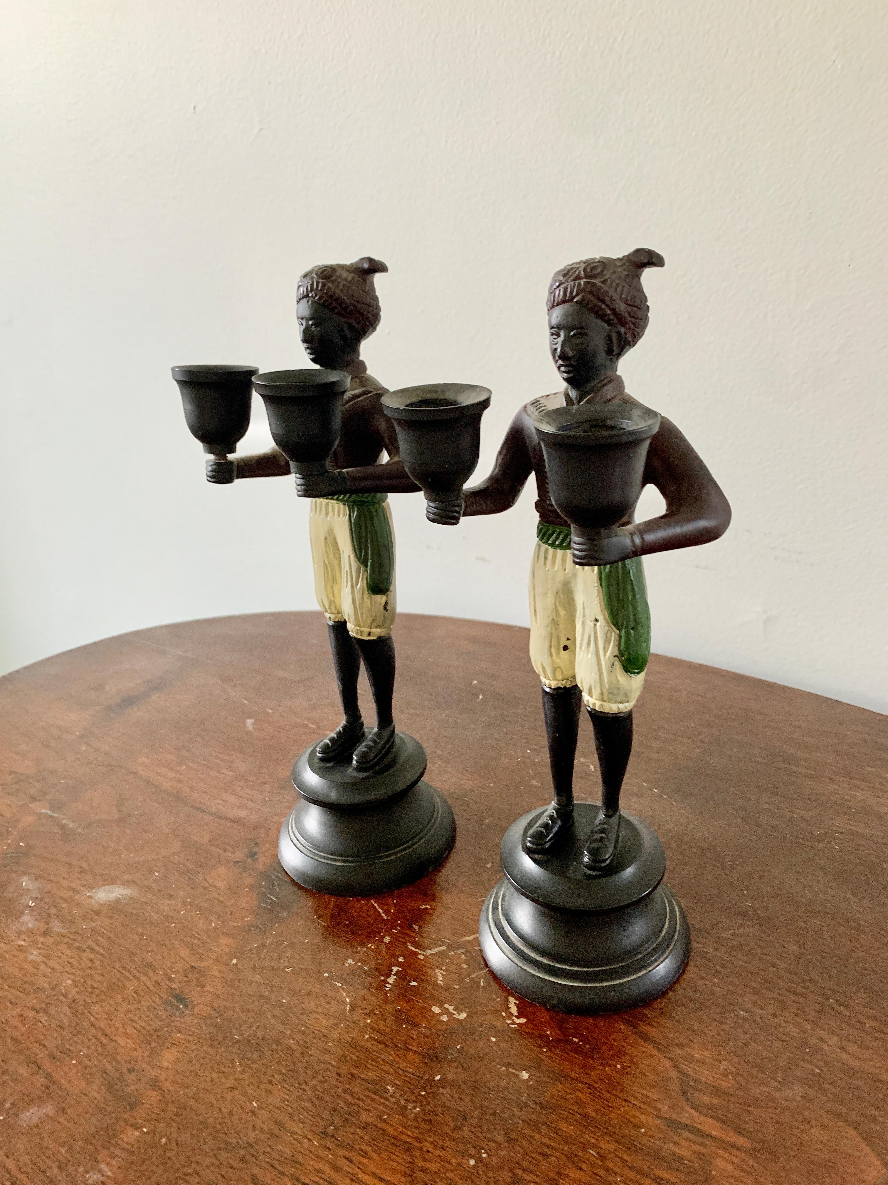 A beautiful pair of cast bronze figurative statues of men carrying two candle cups

USA, Late-20th Century 

Measures: 4