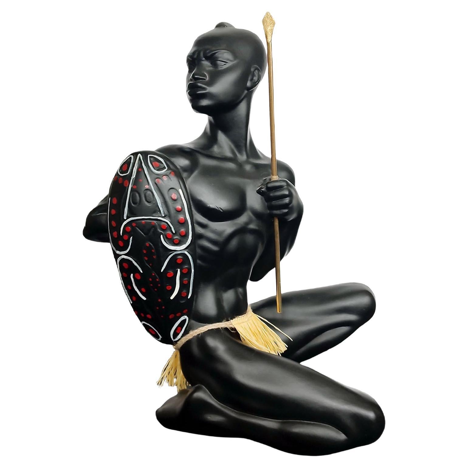 Figurine vintage d'un guerrier africain avec une lance et un bouclier