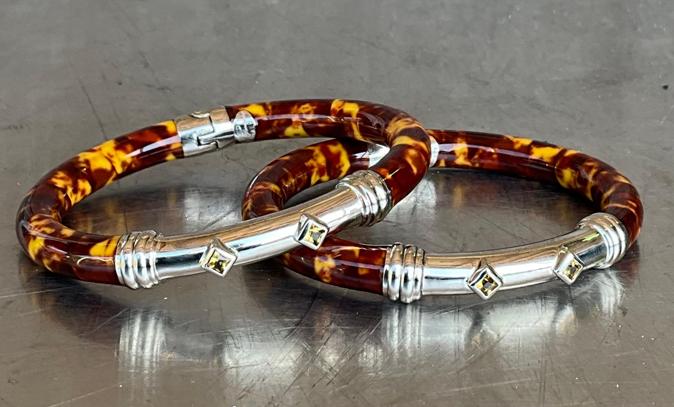 ​Flli Menegatti, established in Italy, is renowned for its exquisite craftsmanship in sterling silver jewelry, often incorporating enamel and gold accents. A set of two vintage Flli Menegatti 925 sterling silver bangles exemplifies the brand's