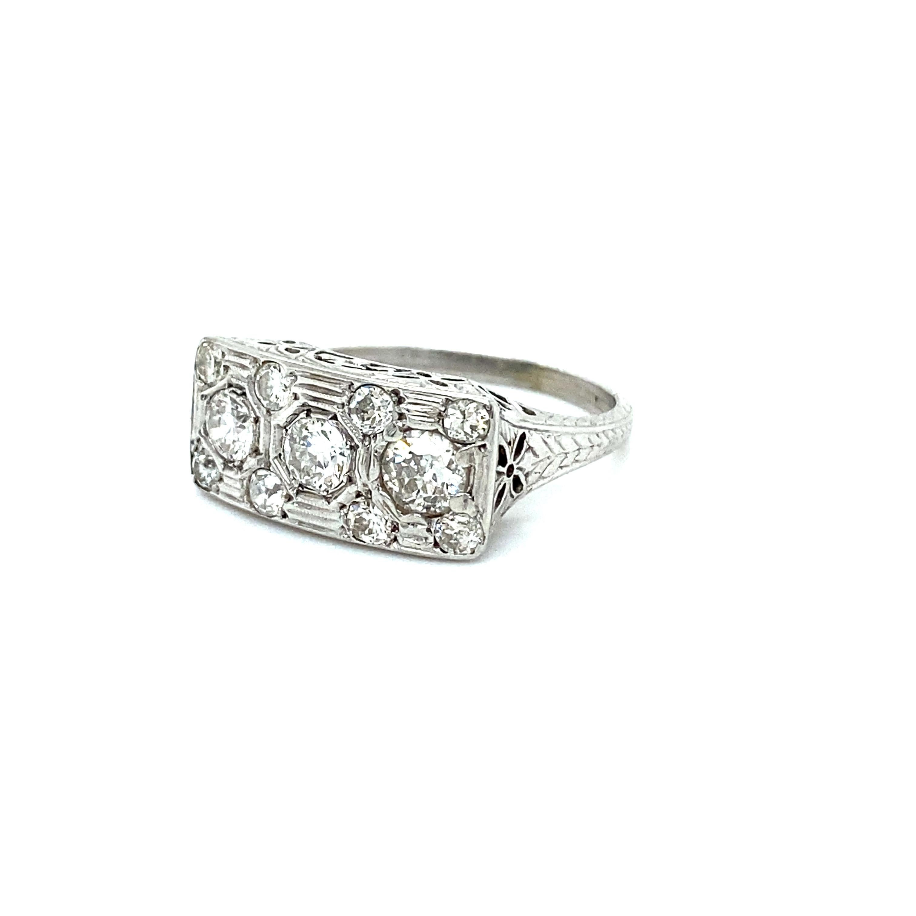 This Vintage Filigree Diamond Cluster Ring Engagement Ring is just gorgeous! Crafted in 18K White Gold, the design features a three stone layout, with additional accent diamonds, and some gorgeous open work filigree! There are a total of 11 Old