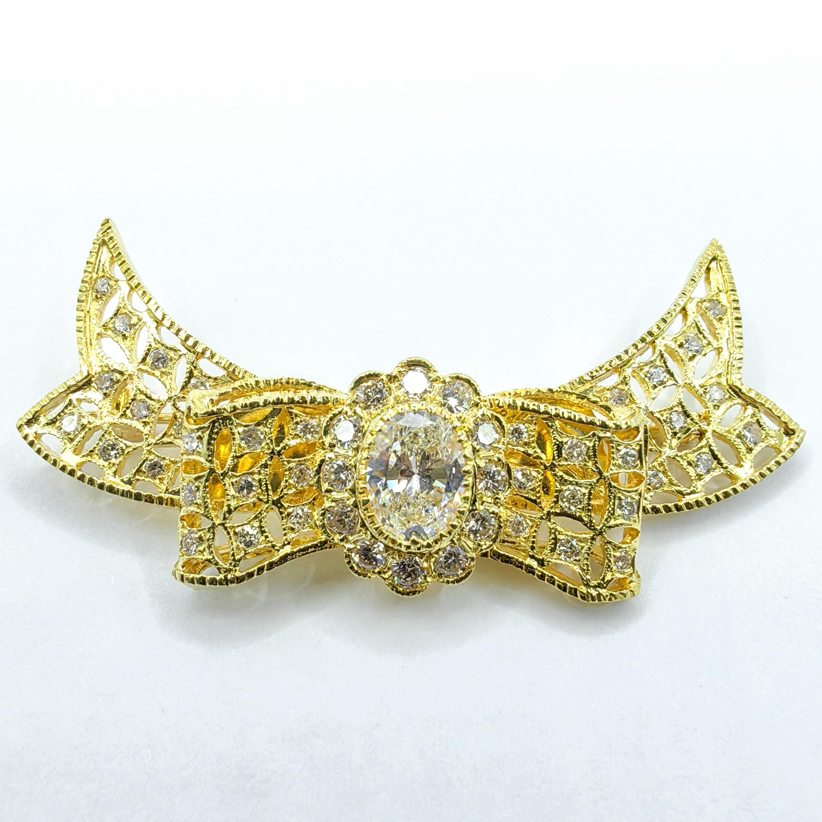 Elegante y atemporal, este broche vintage de diamantes con lazo de filigrana es una impresionante muestra de intrincada artesanía y sofisticación clásica. En su centro, un brillante diamante de talla ovalada de aproximadamente 1 quilate acapara la
