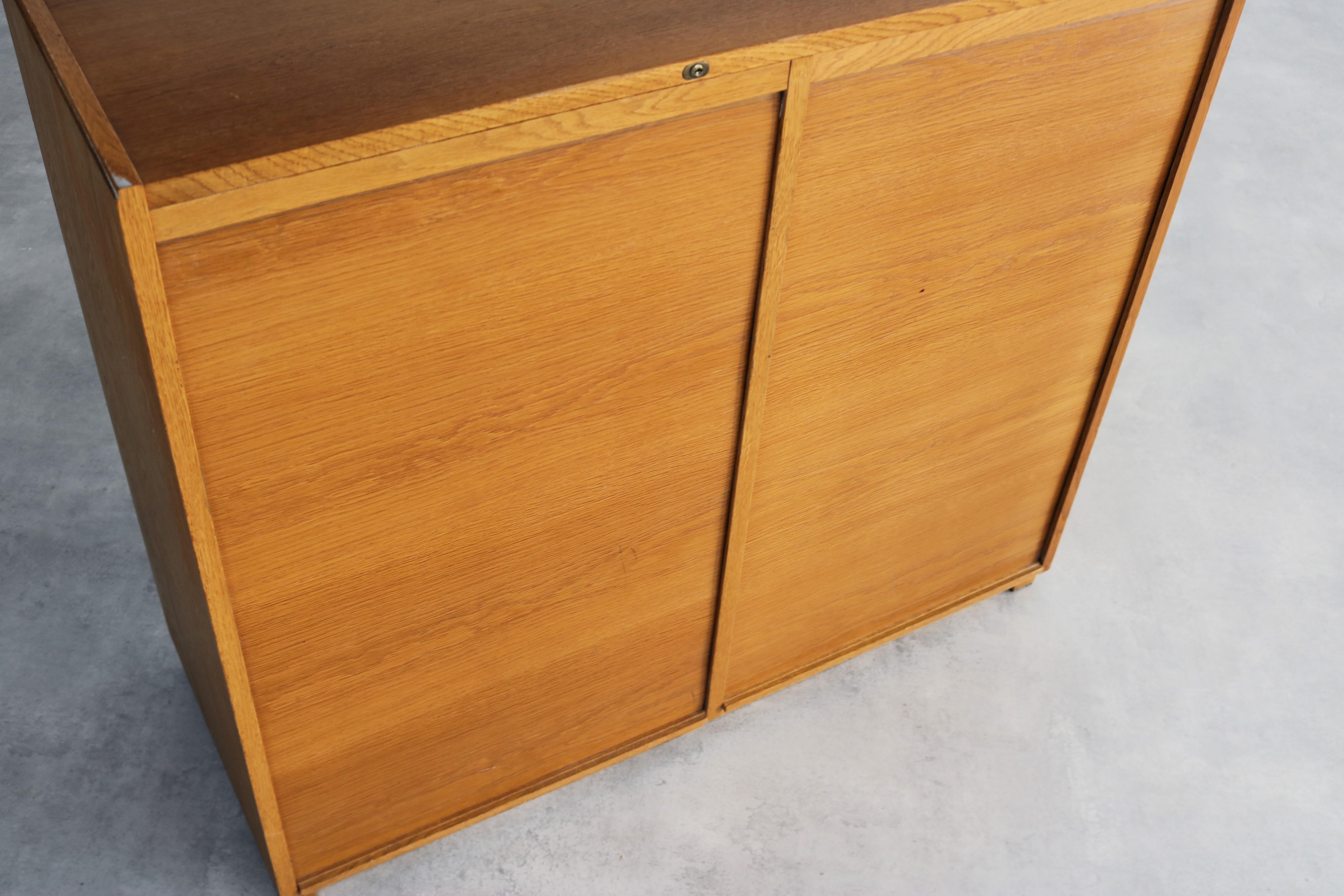 vintage filing cabinet  cupboard  60s  Sweden

period  60's
design  unknown  Sweden
condition  good  light signs of use  key is missing
size  92 x 107 x 43 (hxwxd)

details  oak; plastic; tambour doors;

article number  2206