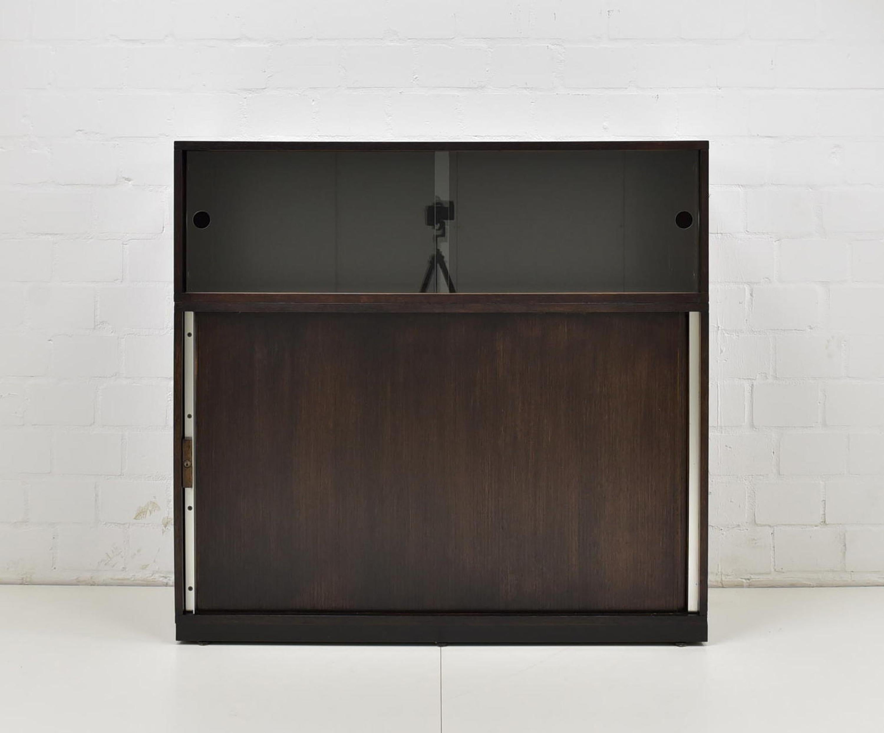 Filing cabinet restored around 1980 office cabinet sliding doors showcase office vintage

Features:
Two-part model with glass sliding doors and lamellar sliding door
Height-adjustable shelves
Smooth sliding mechanism
No-nonsense