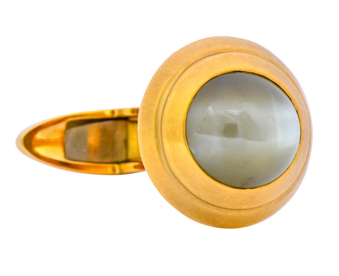 Each cufflink centering a round cabochon cat's eye chrysoberyl measuring approximately 9.0 mm

Cat's eye chrysoberyl are grayish-green and yellowish-green in color with striking chatoyancy featuring milk and honey phenomena

Bezel set in a matte