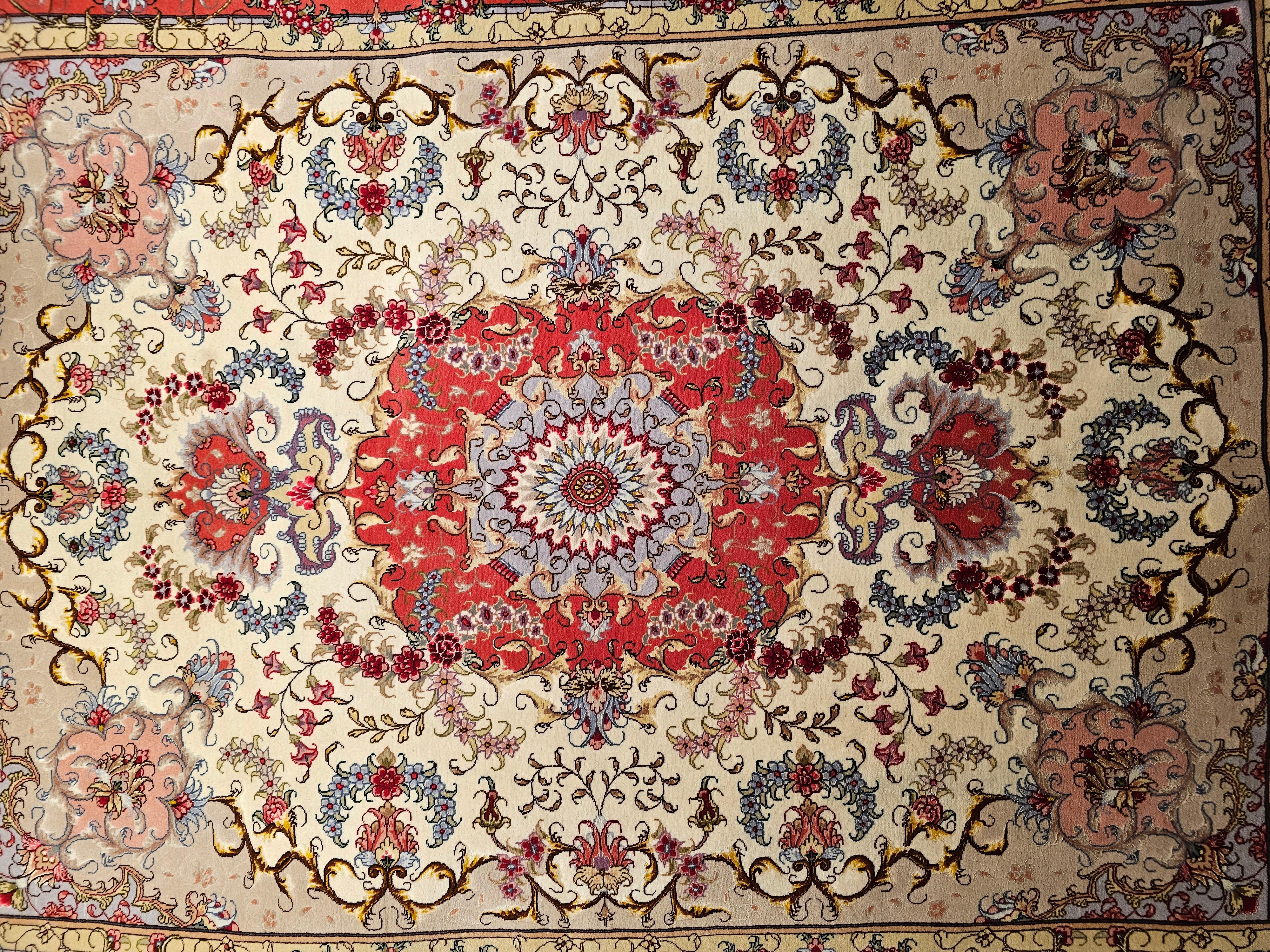 Finely-woven Persian Tabriz area rug in floral design with silk highlights from the late 1900s. The Tabriz rug has a floral “Garden Design” set in an ivory color field with a salmon color border with silk highlighting the designs. The corner