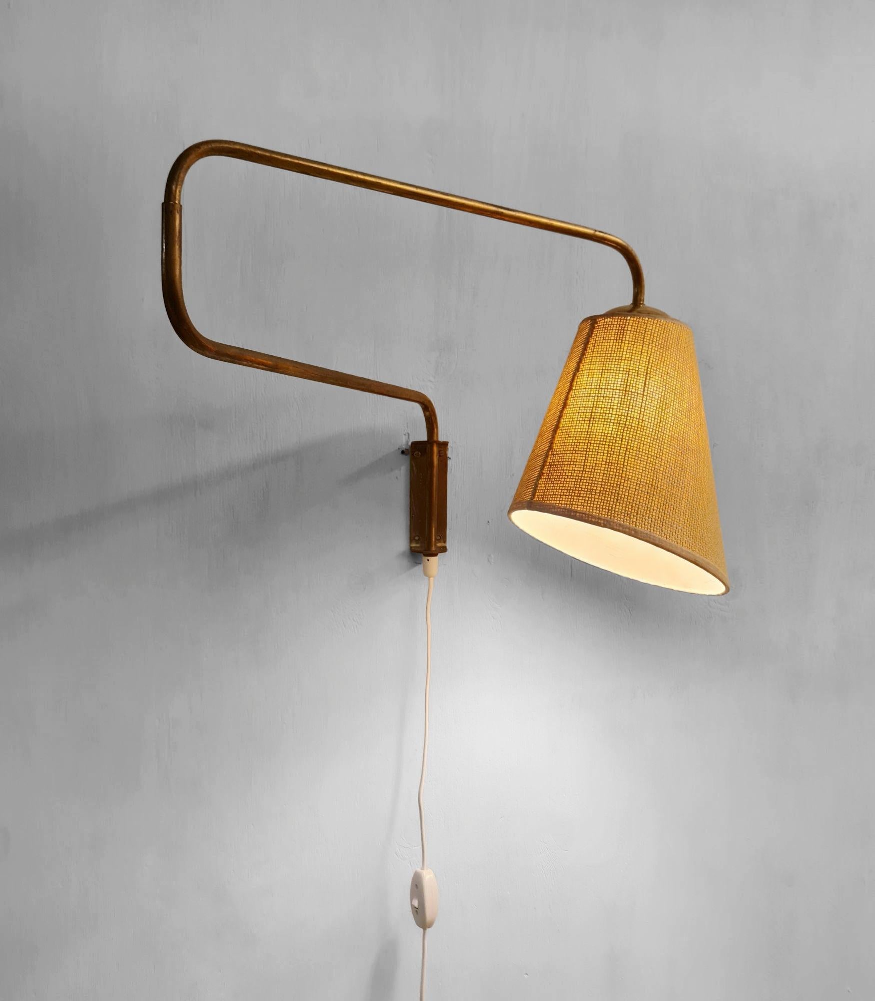 Lampada da parete vintage in ottone e paralume in lino su carta prodotta da Valinte in Finlandia negli anni '50. Il modello della lampada è 2322 e può essere utilizzato con molti paralumi, quello della lampada è il modello 1192. L'illuminazione è