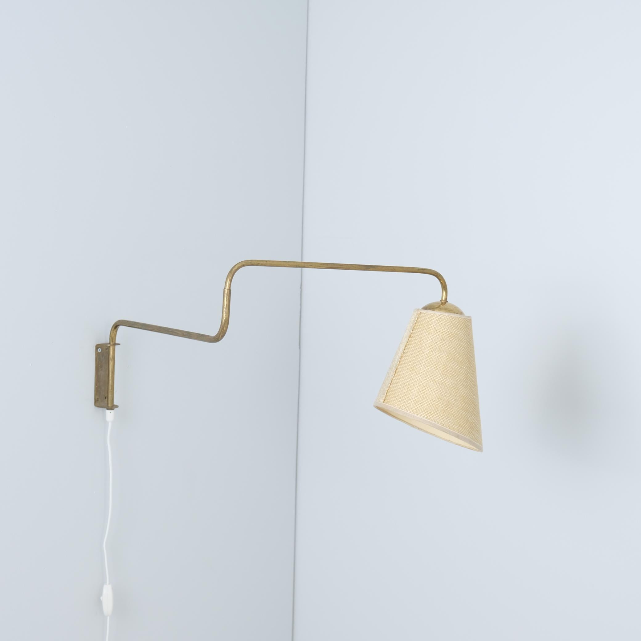 Lampe murale vintage en laiton et abat-jour en lin sur papier fabriquée par Valinte en Finlande dans les années 1950. Le modèle de la lampe est 2322 et pourrait être utilisé avec de nombreux abat-jour, celui de la lampe est le modèle 1192.