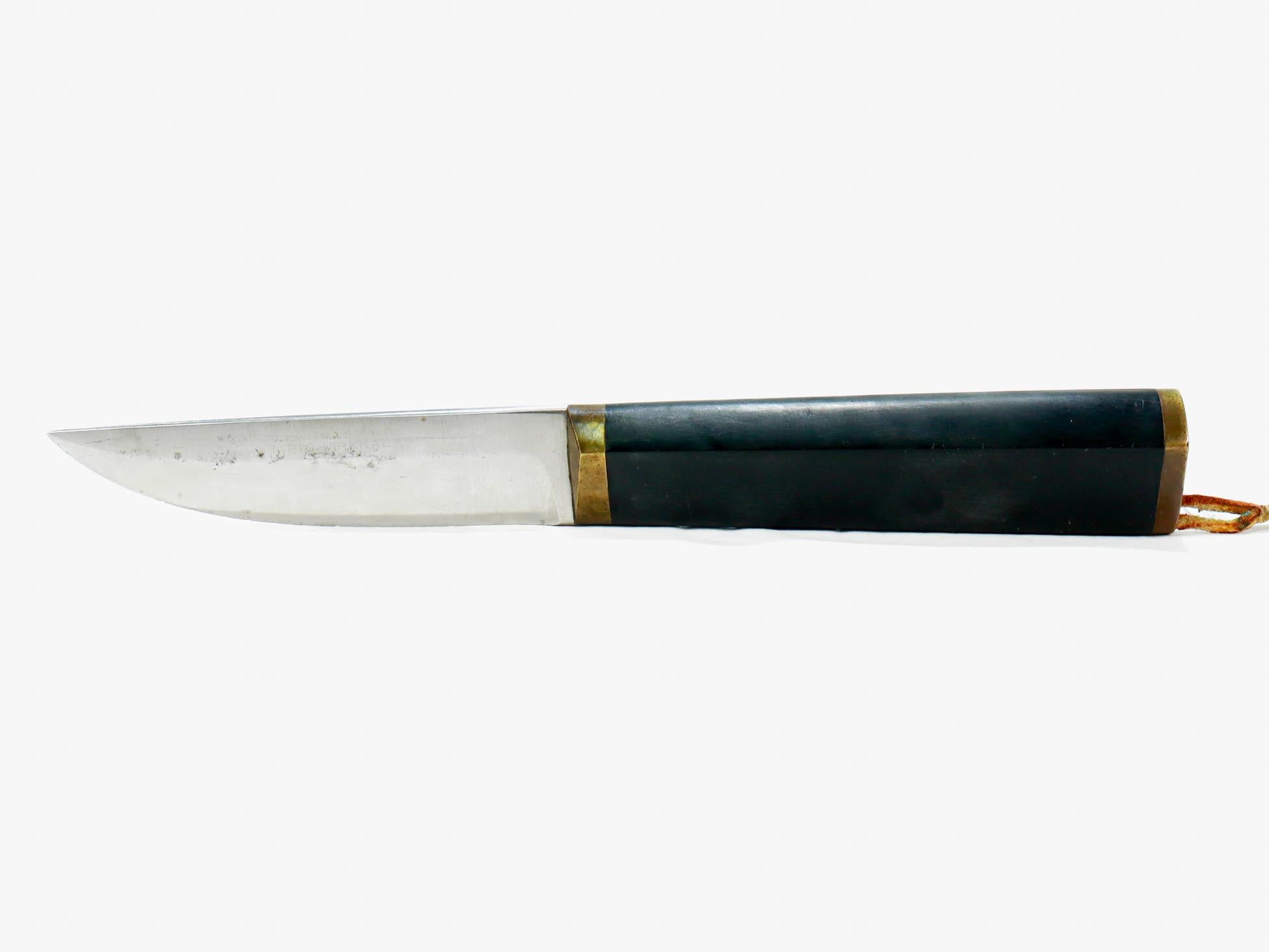 Un beau couteau puukko et son étui datant des années 1960.

Conçu par Tapio Wirkkala et produit par Hackman. 

Le puukko comprend une lame en acier inoxydable, des accessoires en laiton et un manche en nylon noir. Il est accompagné d'un étui en cuir
