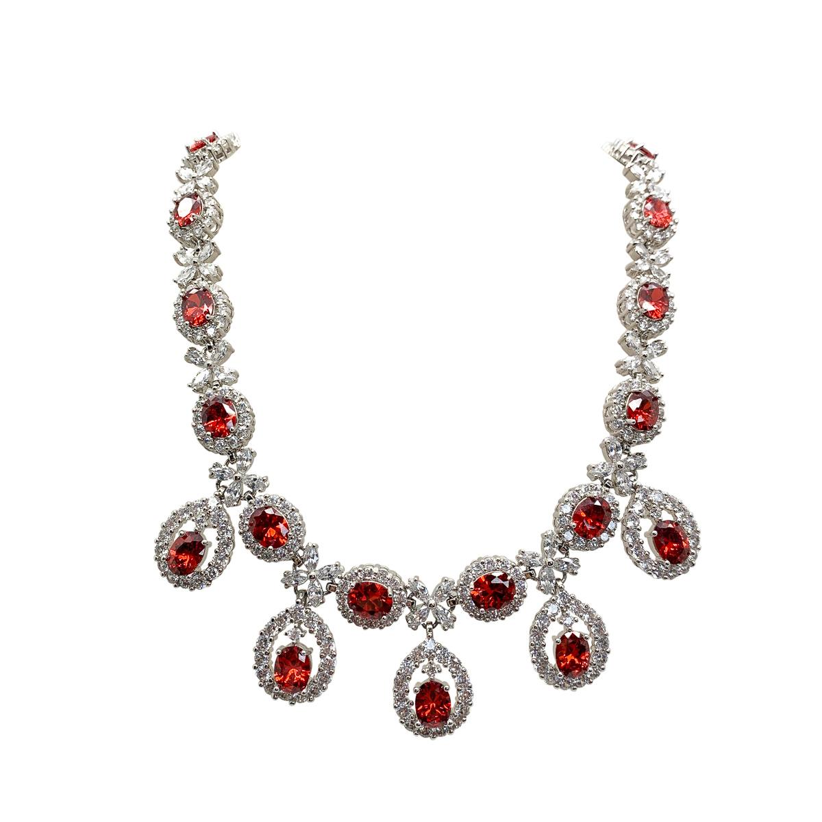 A vintage fire crystal necklace and earrings. Featuring a collar of classic ovals leading droplets topped with marquise stones. The earrings mirroring the necklace design to perfection. The red stones have an orangey red tinge reminiscent of fire