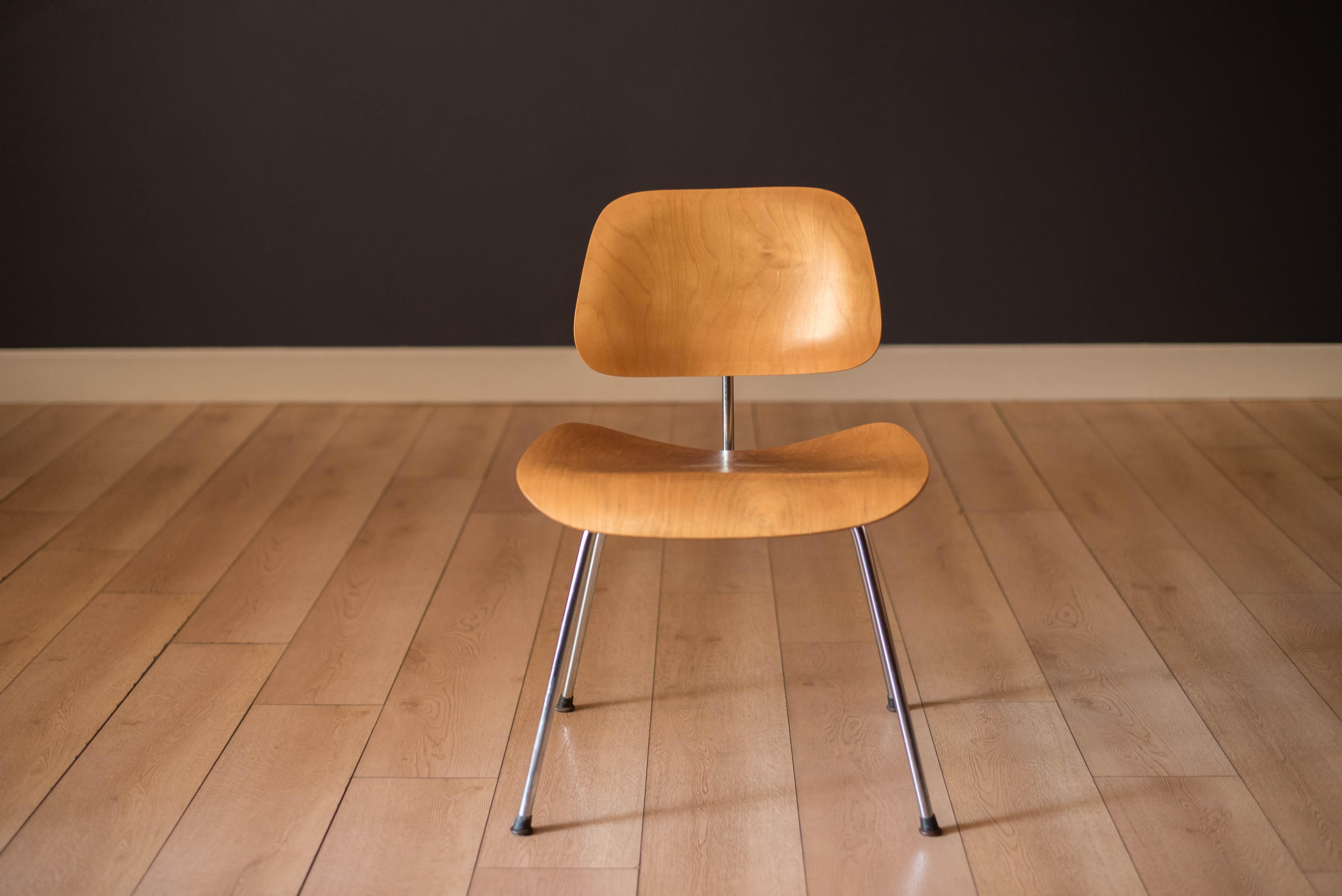 Mid Century Modern DCM dining height side chair by Ray and Charles Eames first generation for Herman Miller circa 1953. This collectible piece features a classic molded plywood seat and backrest in ash wood supported by a sturdy steel rod base.