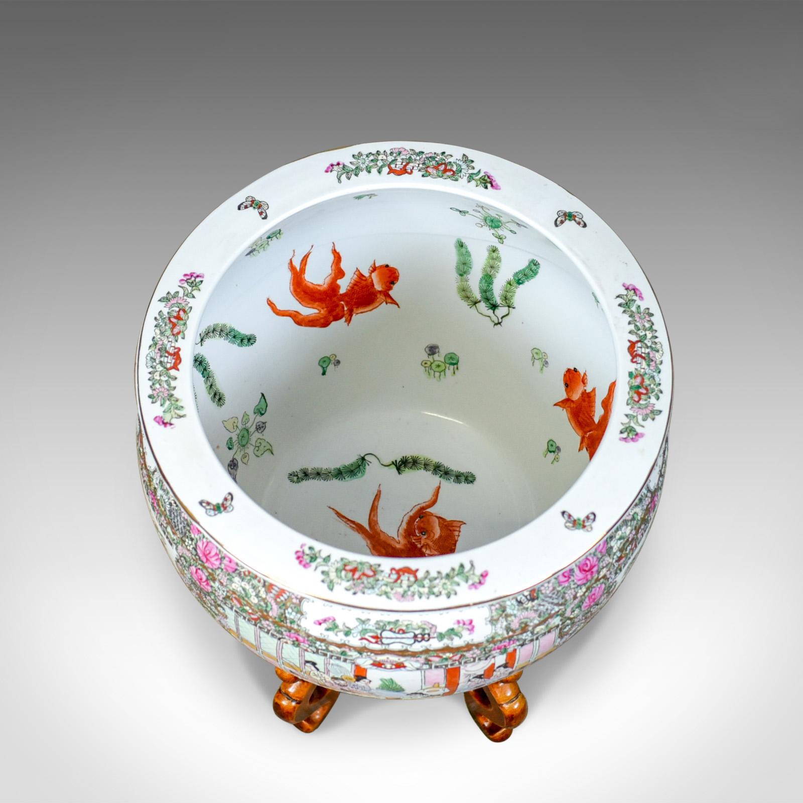 This is a vintage fish bowl on stand, a jardinière plant stand in excellent condition. This Chinese ceramic pot dates from the mid-20th century.

Beautifully presented pottery in 'famille rose' hues 
Profusely decorated with stylised foliate