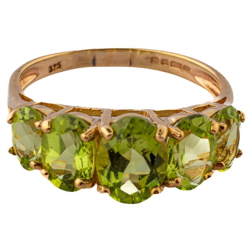 The brightest color of a cat's green eyes shining in the night is cut and set in this five stone peridot ring. The color is far far more clear and bright than the photos show. Clear gems not backed or foiled allows light flood through the peridots.