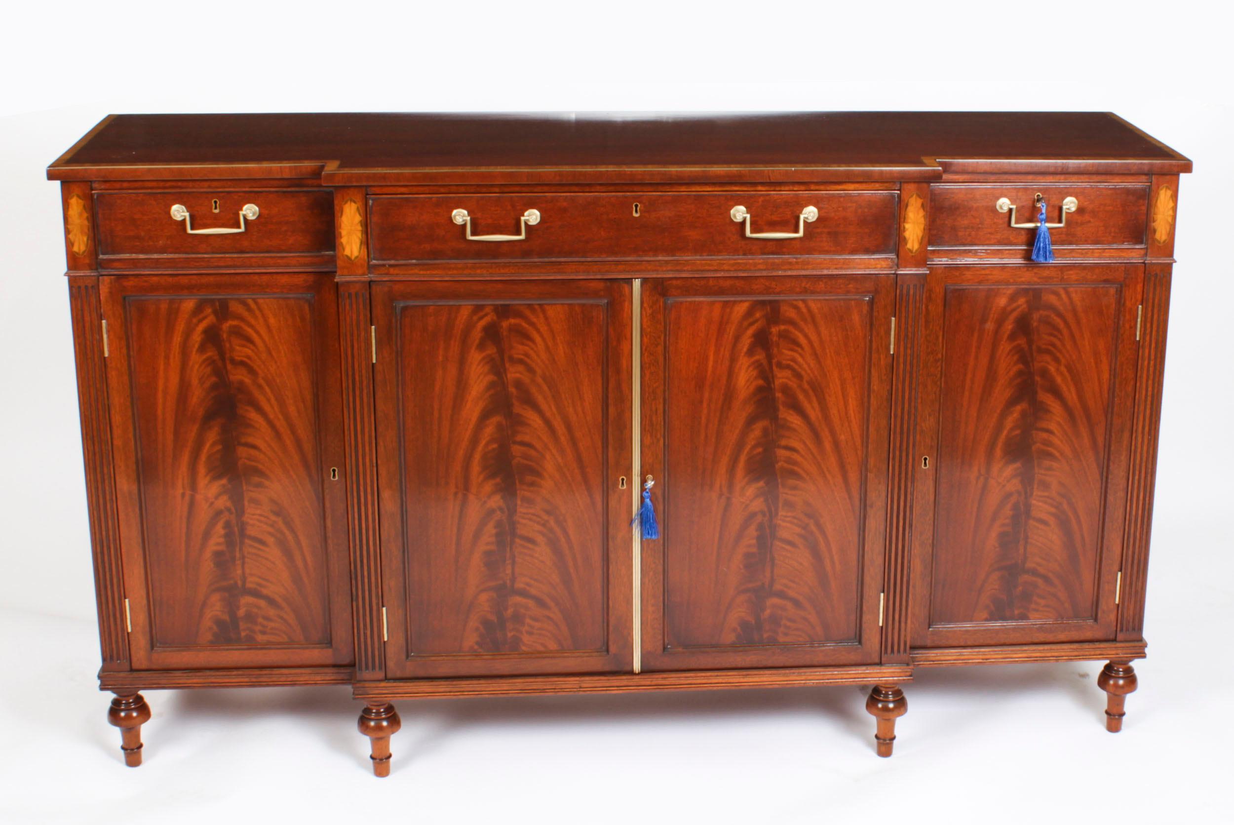 This is a fabulous vintage Regency Revival breakfront sideboard by the master cabinet maker William Tillman, circa 1980 in date.

It is made of stunning flame mahogany crossbanded in satinwood, fitted with drawers and cupboards and raised on