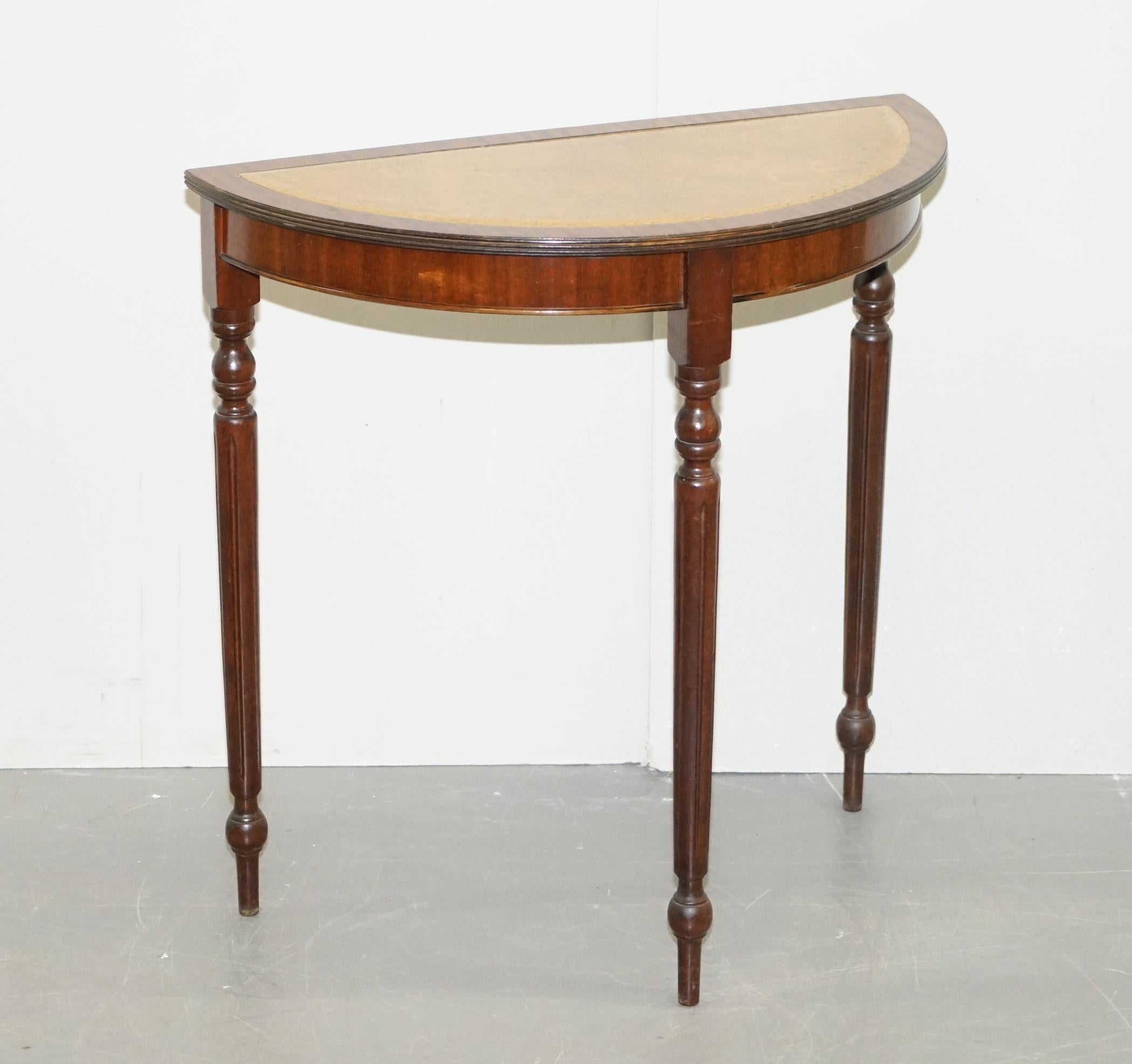 We are delighted to offer for sale this lovely vintage flamed mahogany demi lune console table with faded tan leather top

A nice looking and unitarian table, ideally suited with an occasional chair either side

We have cleaned waxed and