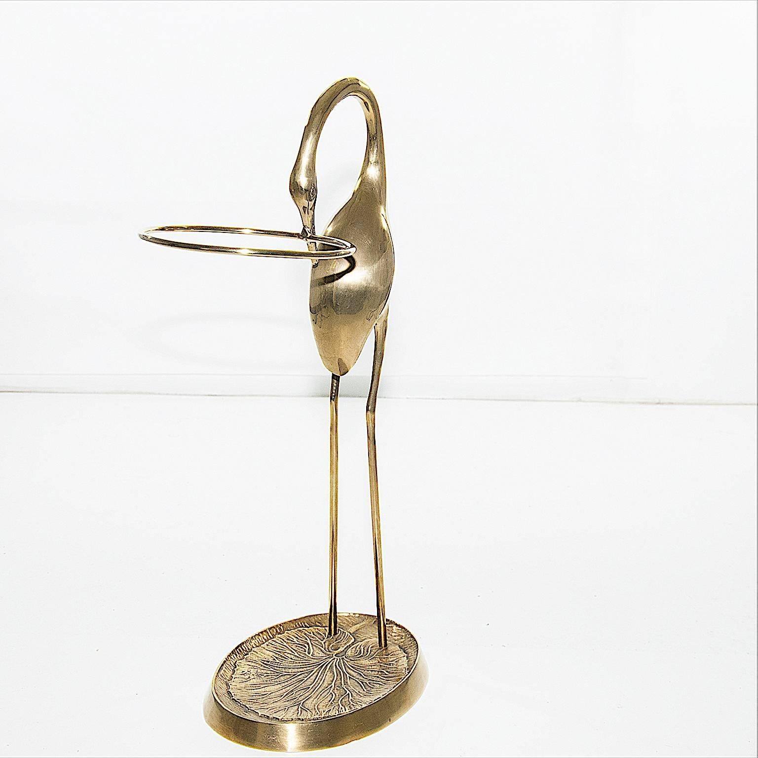 This rack is a sculpture too, in solid brass, in a high quality, elegant and heavy. His weigh is around 5 kg.
The bird is a Flamengo, that holds in his mouth the circla brass element into witch, we put canes and umbrellas.
   