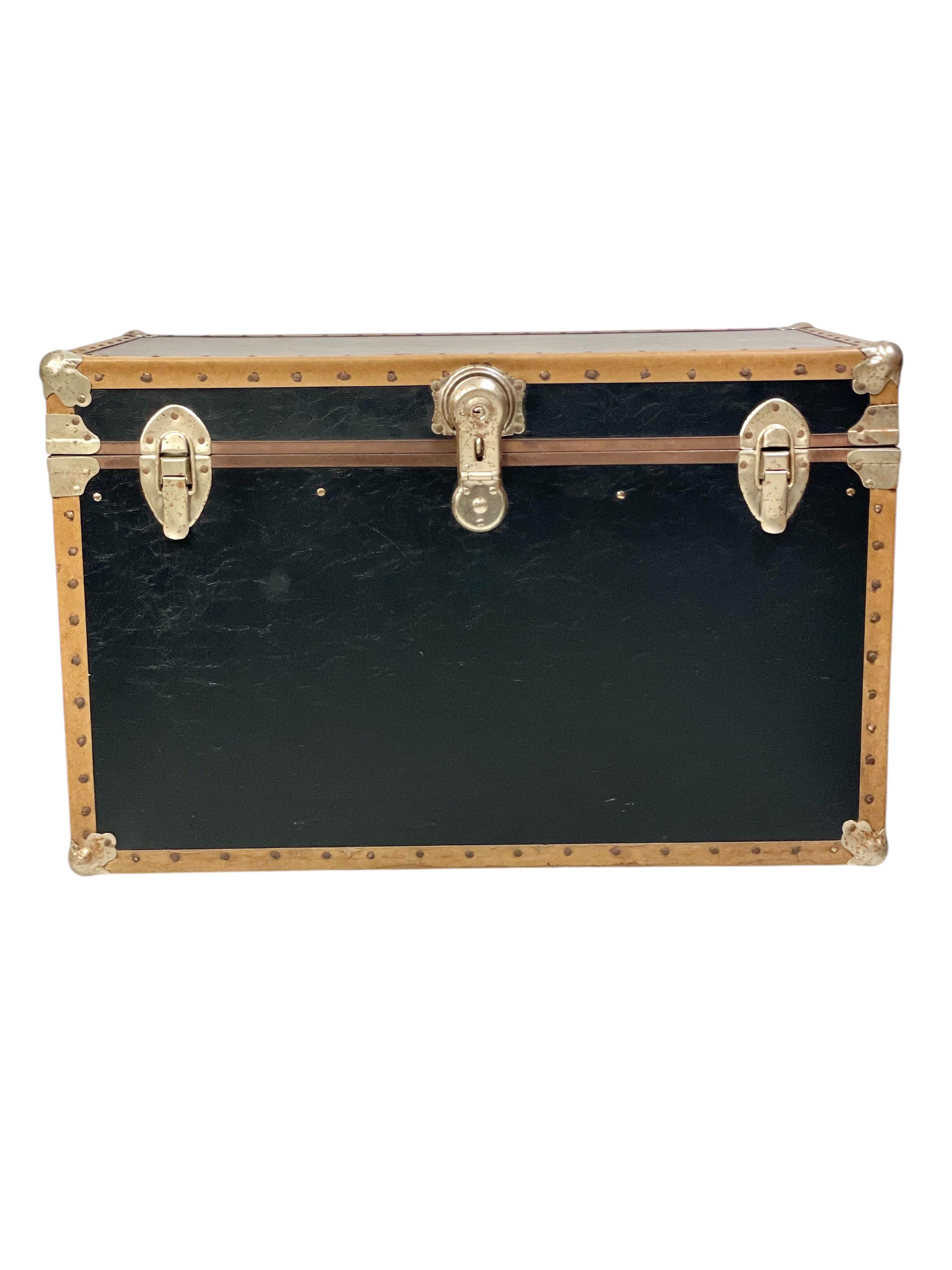 Questo straordinario baule a vapore vintage combina una funzionalità senza tempo con un design classico. Probabilmente risalente alla metà del XX secolo, il pezzo è caratterizzato da una robusta struttura in legno rivestita in tela o similpelle