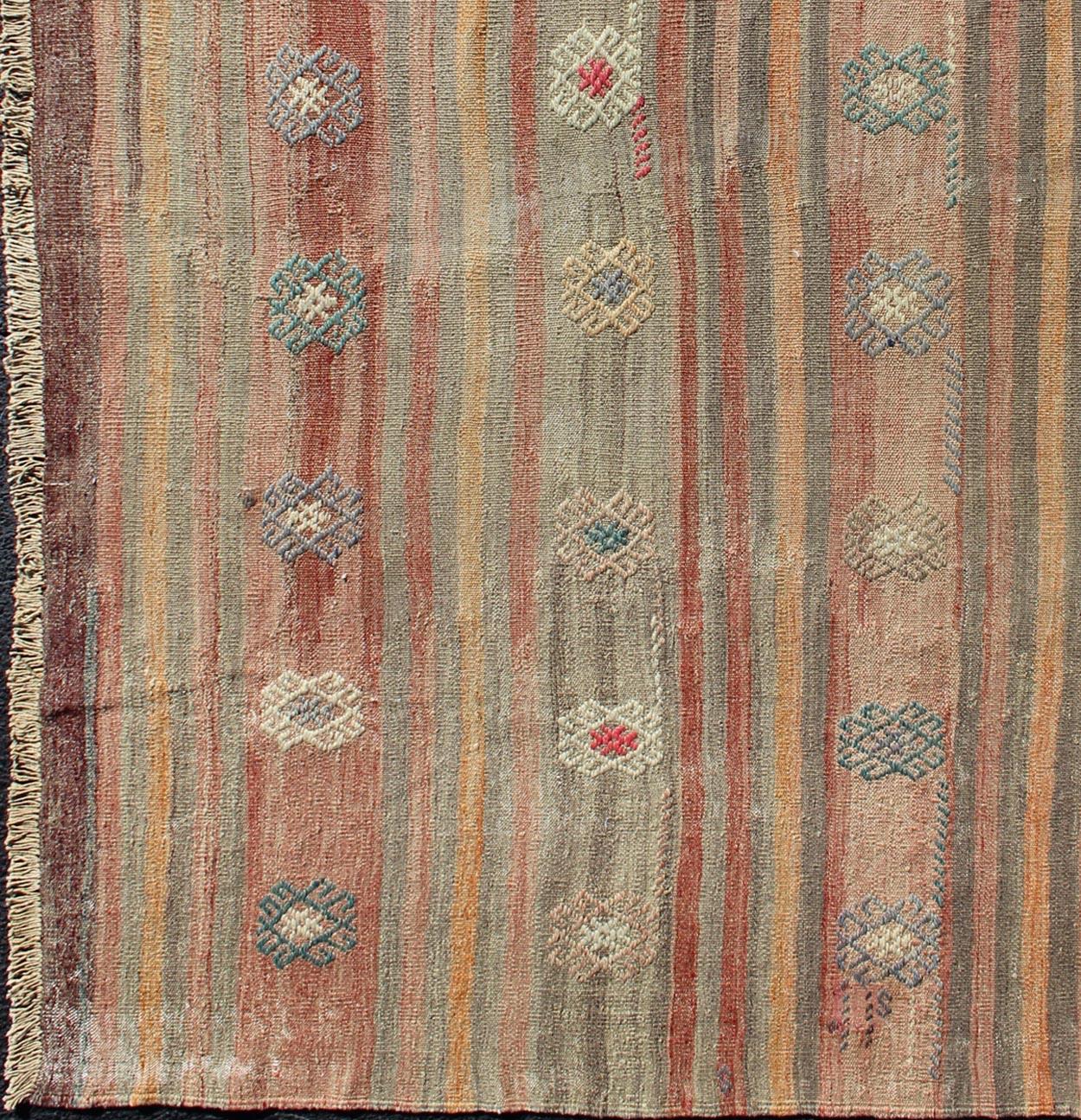Turkish vintage flat-woven Kilim with repeating pattern, rug TU-NED-604, country of origin / type: Turkey / Kilim, circa 1950.

This flat-woven Kilim rug displays an enchanting design of repeating starburst motifs, rendered in orange, burnt red,