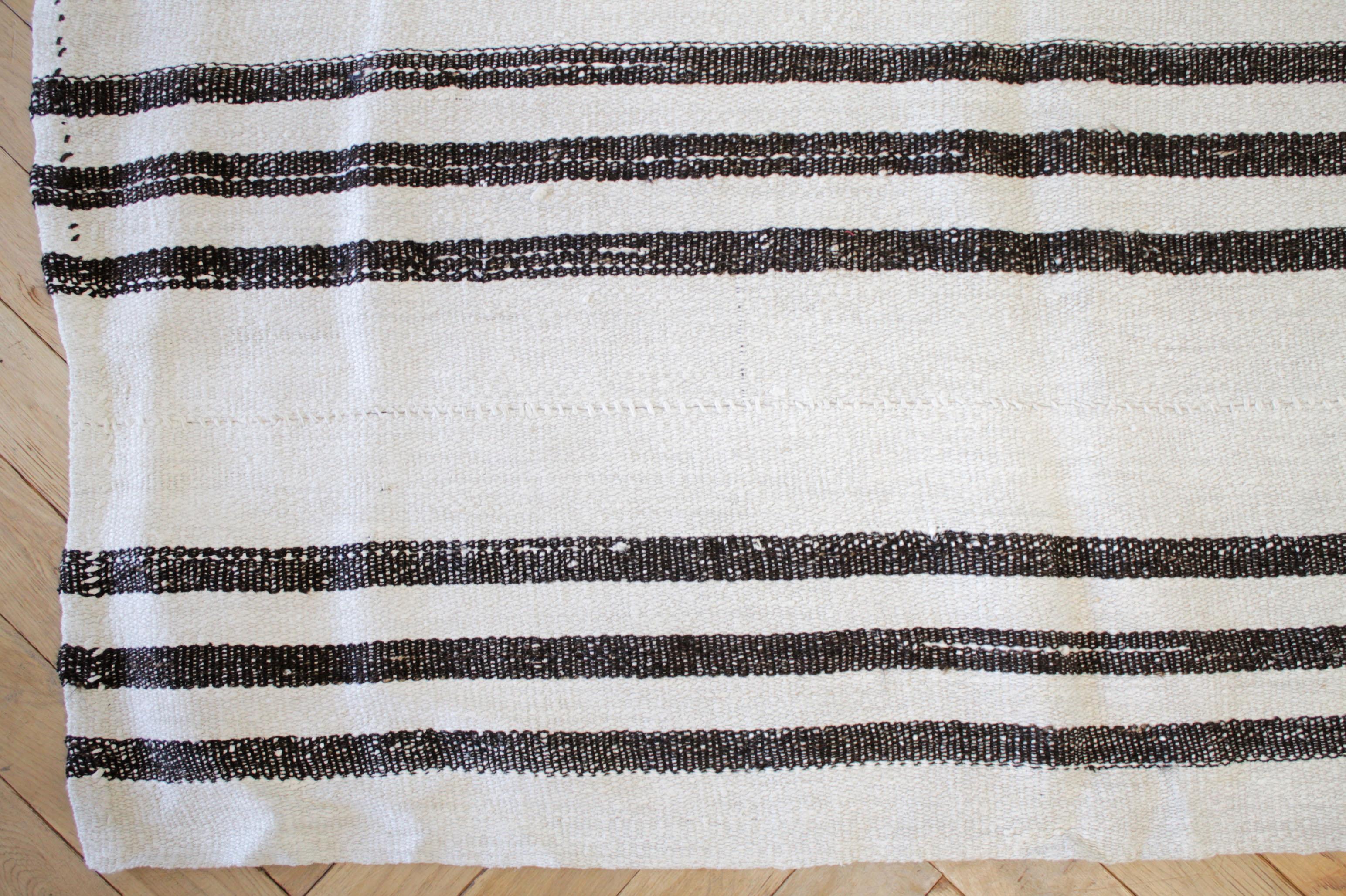 Vintage flat-weave Turkish Hemp rug in creamy white and brown stripes.
Our latest collection has arrived from Turkey, these are great to use as a rug, or let us create a custom ottoman for your out of this piece. 
Flat-weave, wool and goat hair,