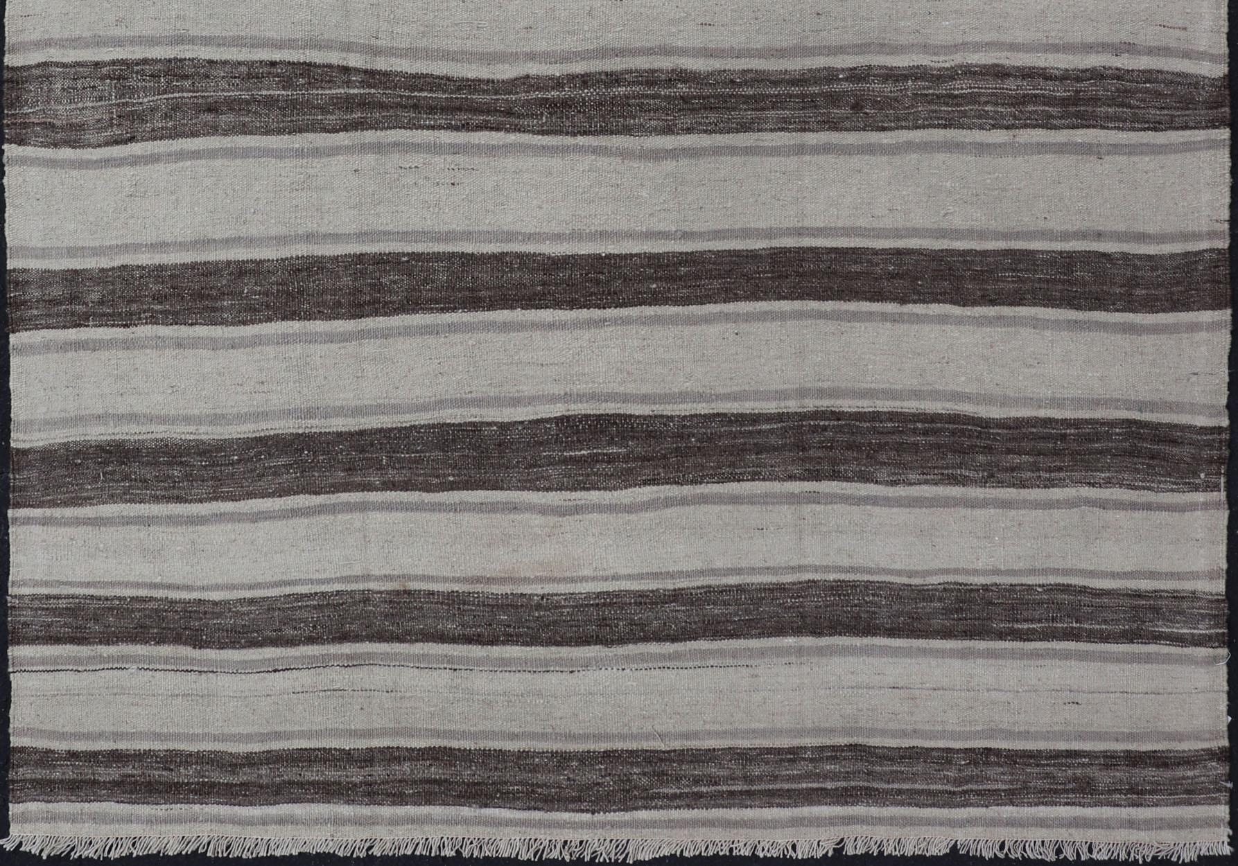 Vintage Flat Weave Turkish Kilim with stripes in ivory, grey, and charcoal. Keivan Woven Arts / rug EN-P13424, country of origin / type: Turkey / Kilim, circa Mid-20th Century.

This vintage flat-woven Kilim features a Minimalist design rendered in