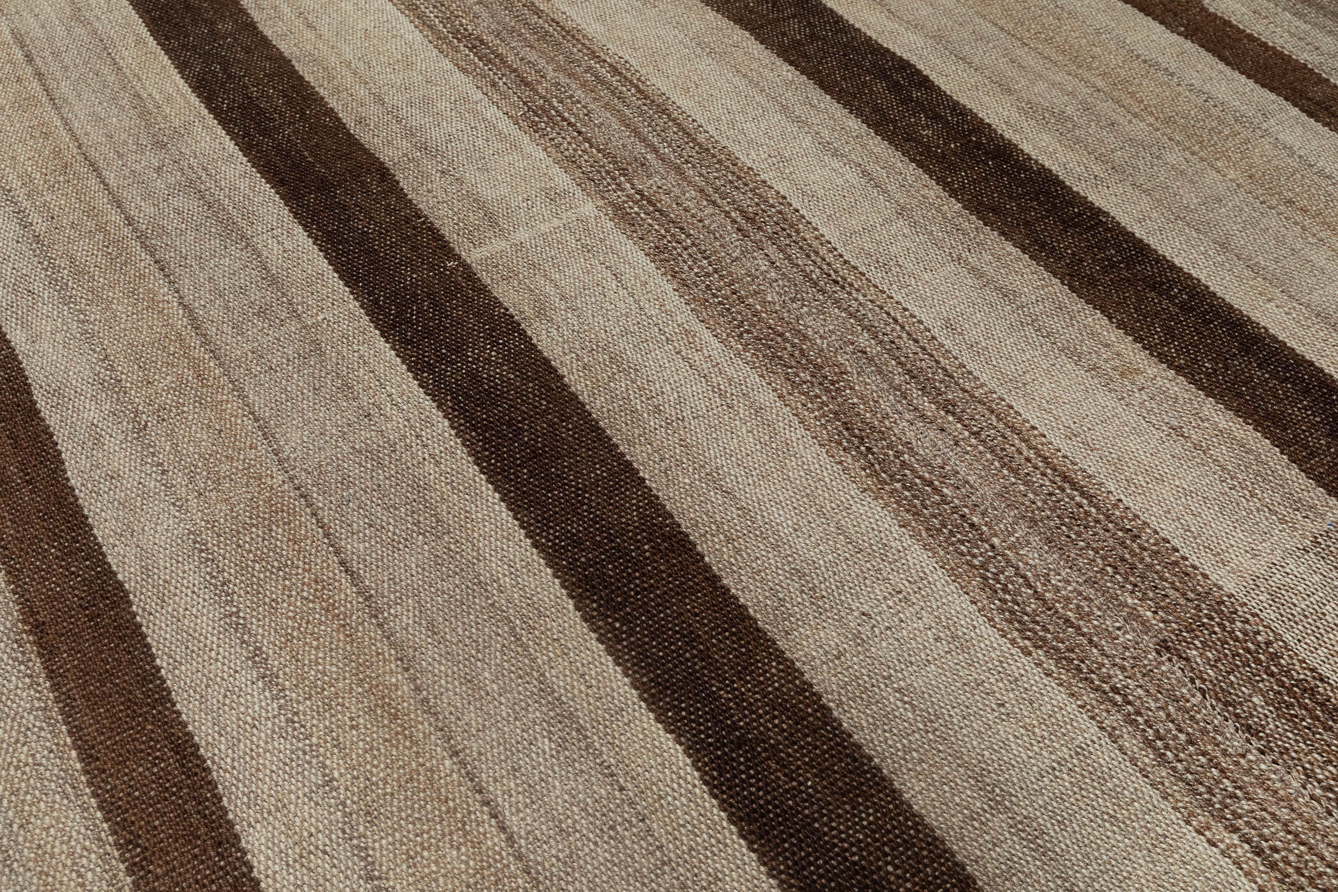 Questo elegante tappeto kilim vintage a tessitura piatta presenta un design a righe senza tempo in una serena tavolozza di toni naturali della lana, che vanno dal caldo taupe e dal morbido beige al delicato moka. Intrecciato a mano a metà del XX