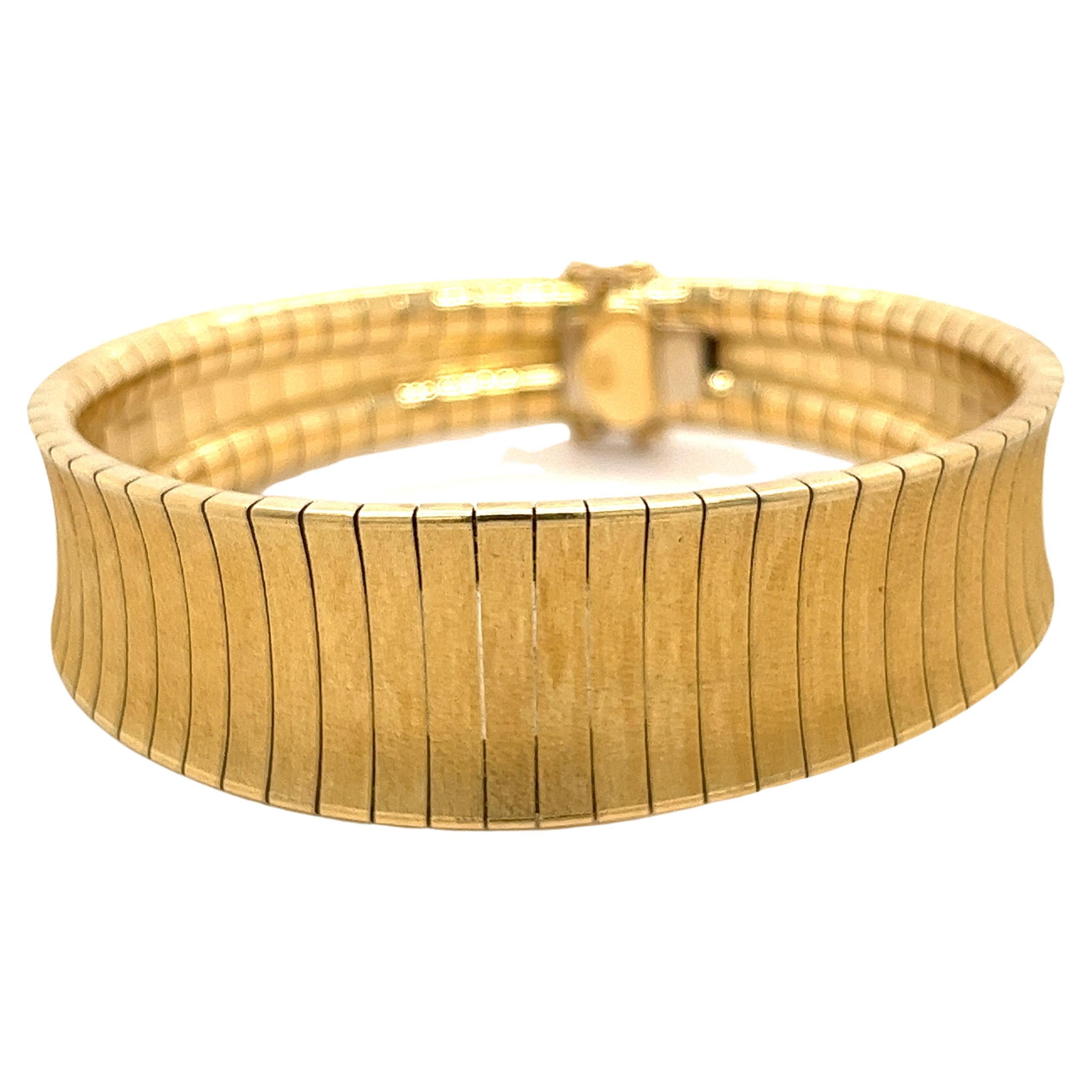 Flexible 18 karat yellow gold vintage bracelet with a textured matte finish. Secure box closure with a smooth back that glides gracefully on the wrist. This bracelet seamlessly wraps around the wrist for a super comfortable fit. Made to be worn