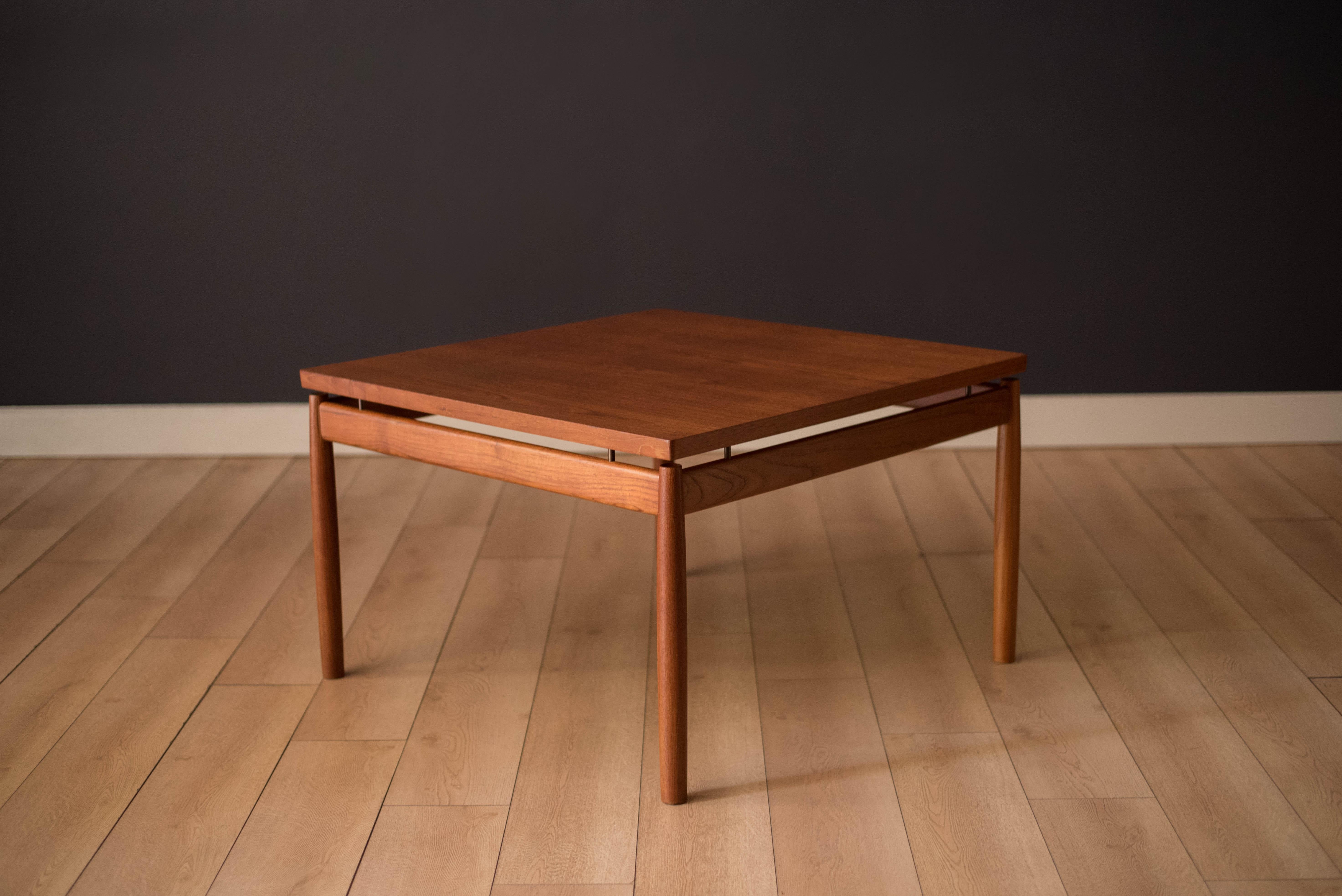 Mid century modern square coffee table designed by Grete Jalk for France & Daverkosen in teak. This timeless piece features brass accents and functions as a coffee table, occasional table, or sectional sofa end table.