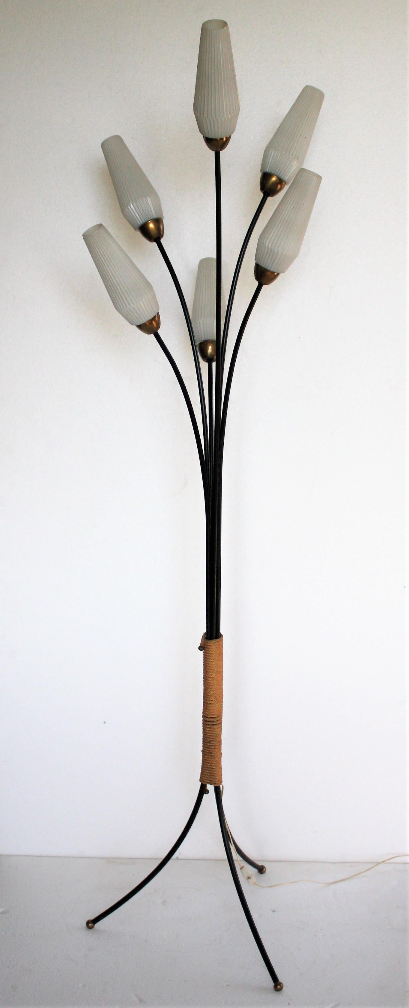 Elegant flower like black metal floor lamp with six ribbled white glass lamp shades.

Typical and charming fifties design.

The lamp has brass shade holders and brass feet and comes with the original 'cord' decoration in the centre.

Perfect