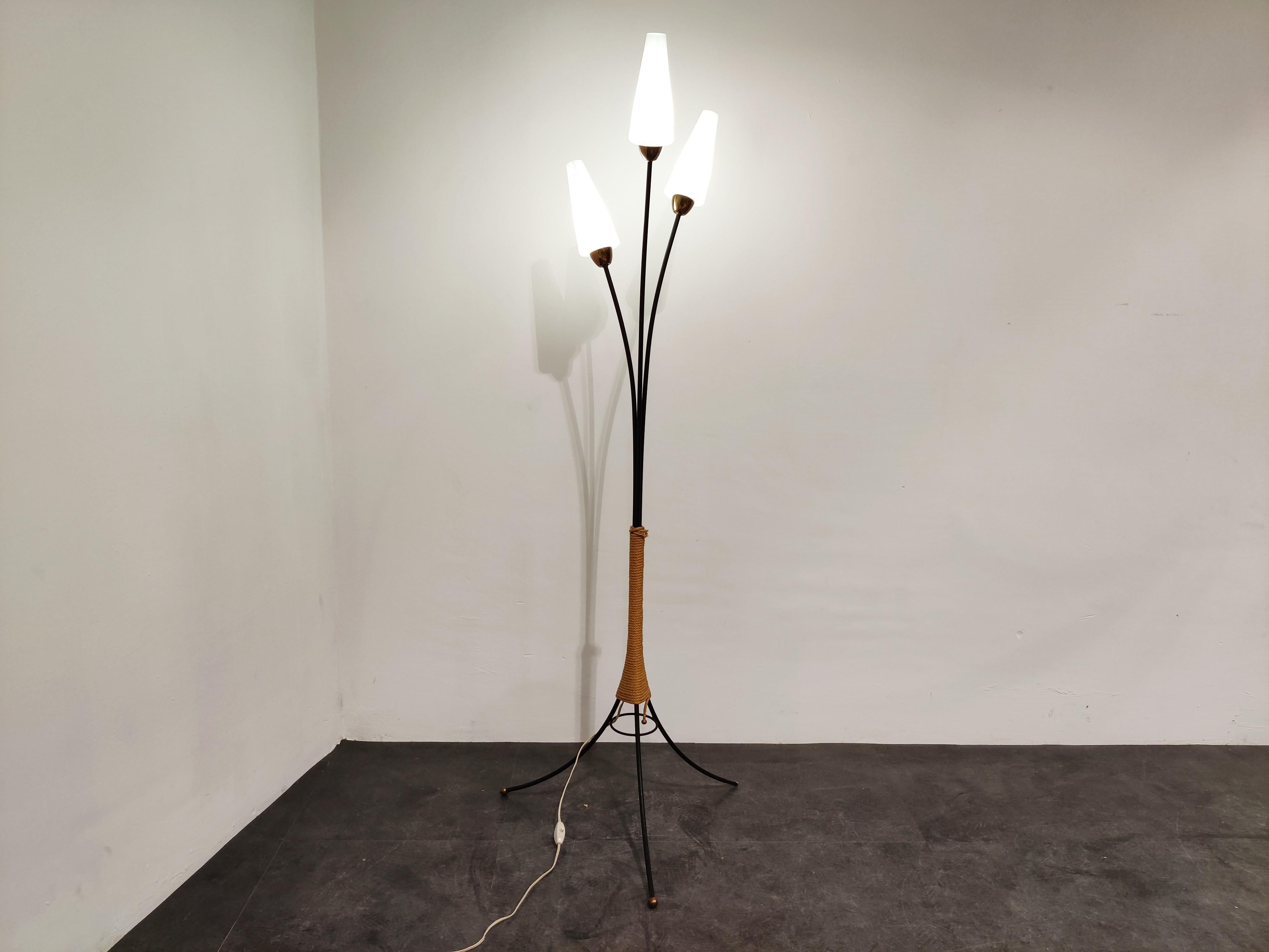 Elegant midcentury floor lamp with metal frame and opaline glasses.

Typical and charming 1950s design.

The lamp has brass shade holders and brass feet and comes with the original 'cord' decoration in the center.

Perfect condition.

Tested