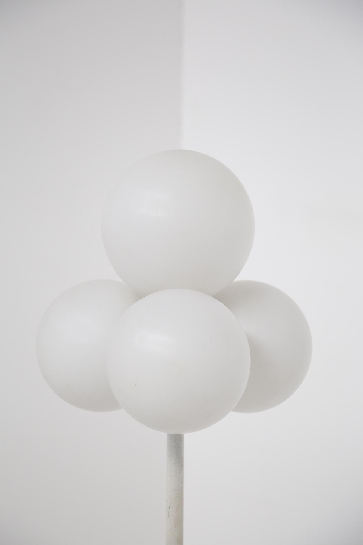Spectacular floor lamp designed by Max Bill in the 60's, of fine Italian manufacture.
The lamp consists of a white aluminum stem, which ends with a staggered bell-shaped structure that holds the central body of the lamp. The floor lamp has a round