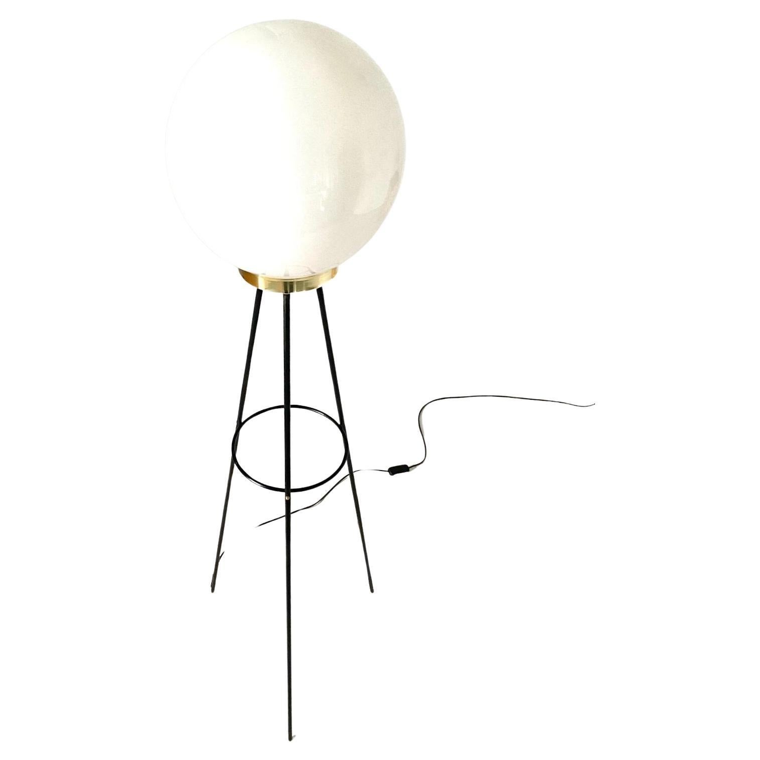 A 1950s vintage floor lamp by Stilnovo, Italy. Tripode structure made of 3 iron black sticks that support an white opaline bowl with brass base. Restored as follows:

Rewired and new electrical parts;
Iron parts have been repainted;
Brass ringd has