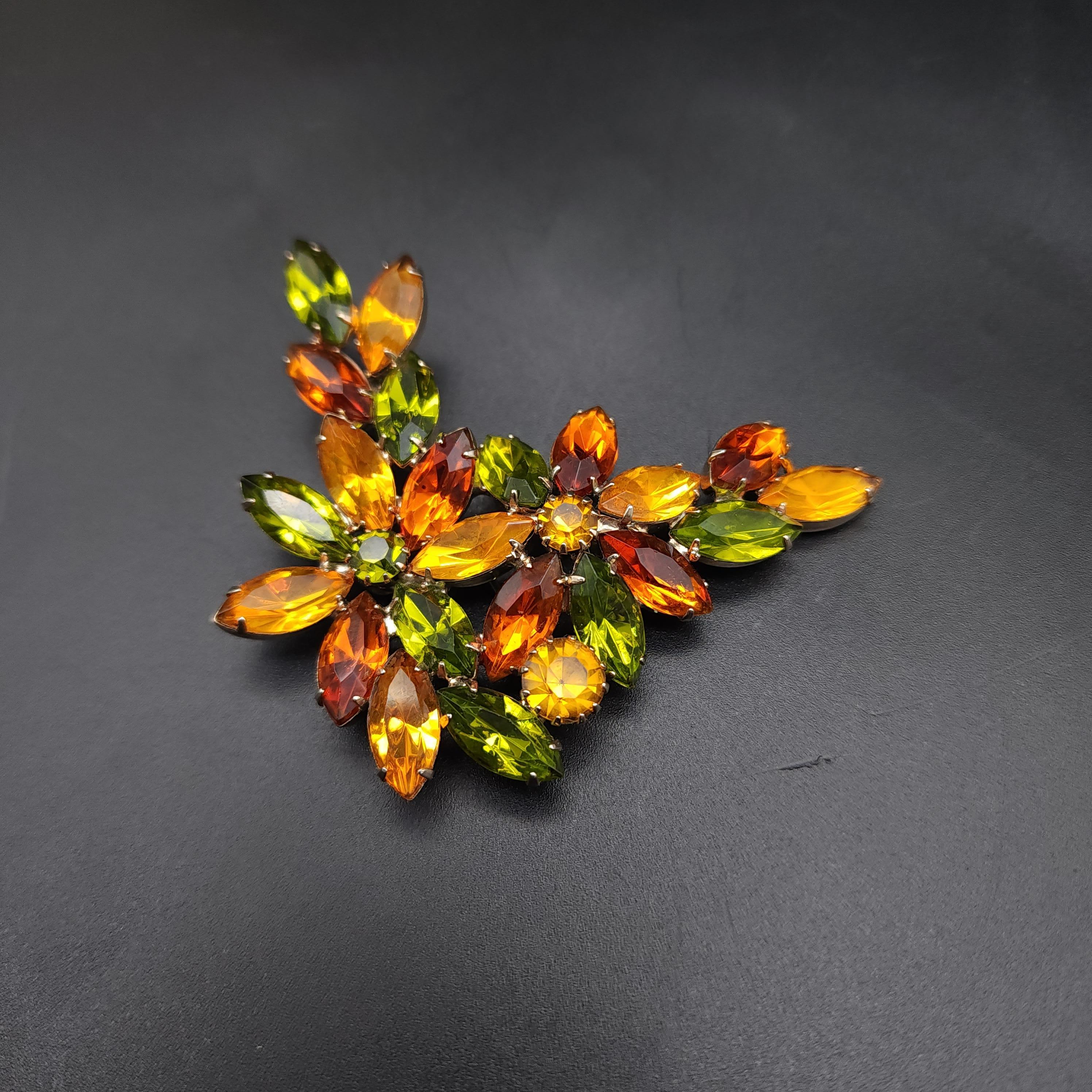 Größe: 3 x 2,75 Zoll
Glas-Kristalle
Hellgoldfarbene Metallfassung

Entdecken Sie den Retro-Charme dieser floralen Brosche im Vintage-Stil, die mit einer funkelnden Gruppe von Kristallen im Marquise- und Rundschliff besetzt ist. Die Brosche ist in