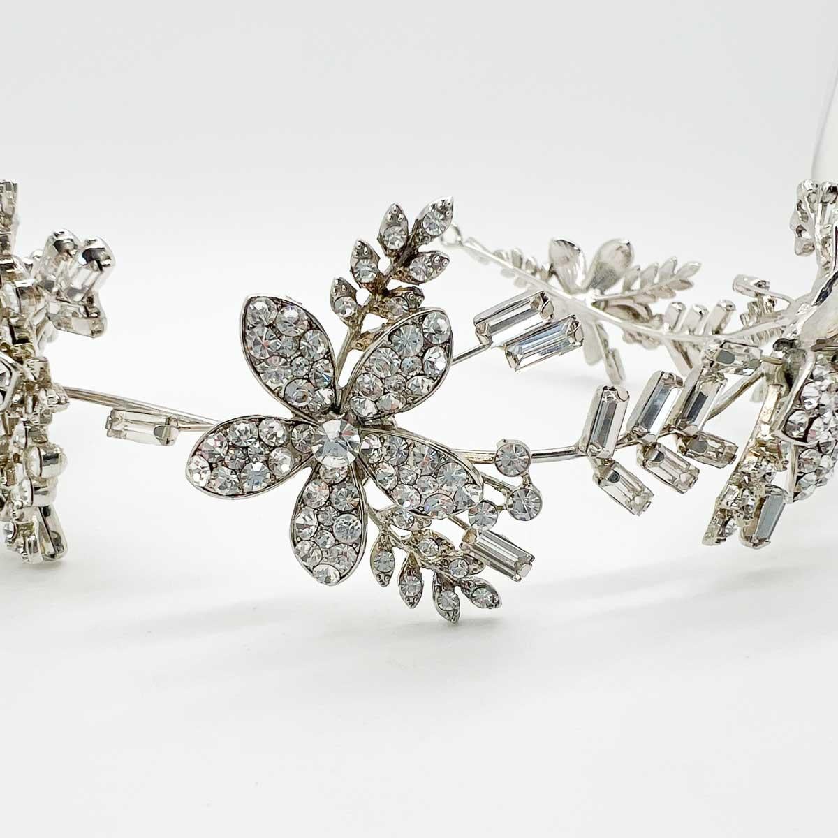 Una bellissima tiara floreale vintage. Un'incantevole serie di cristalli di fantasia adorna il design di questo diadema floreale senza tempo.
Una bellezza non firmata. Un tesoro raro. Solo perché un gioiello non porta il nome di un designer, non