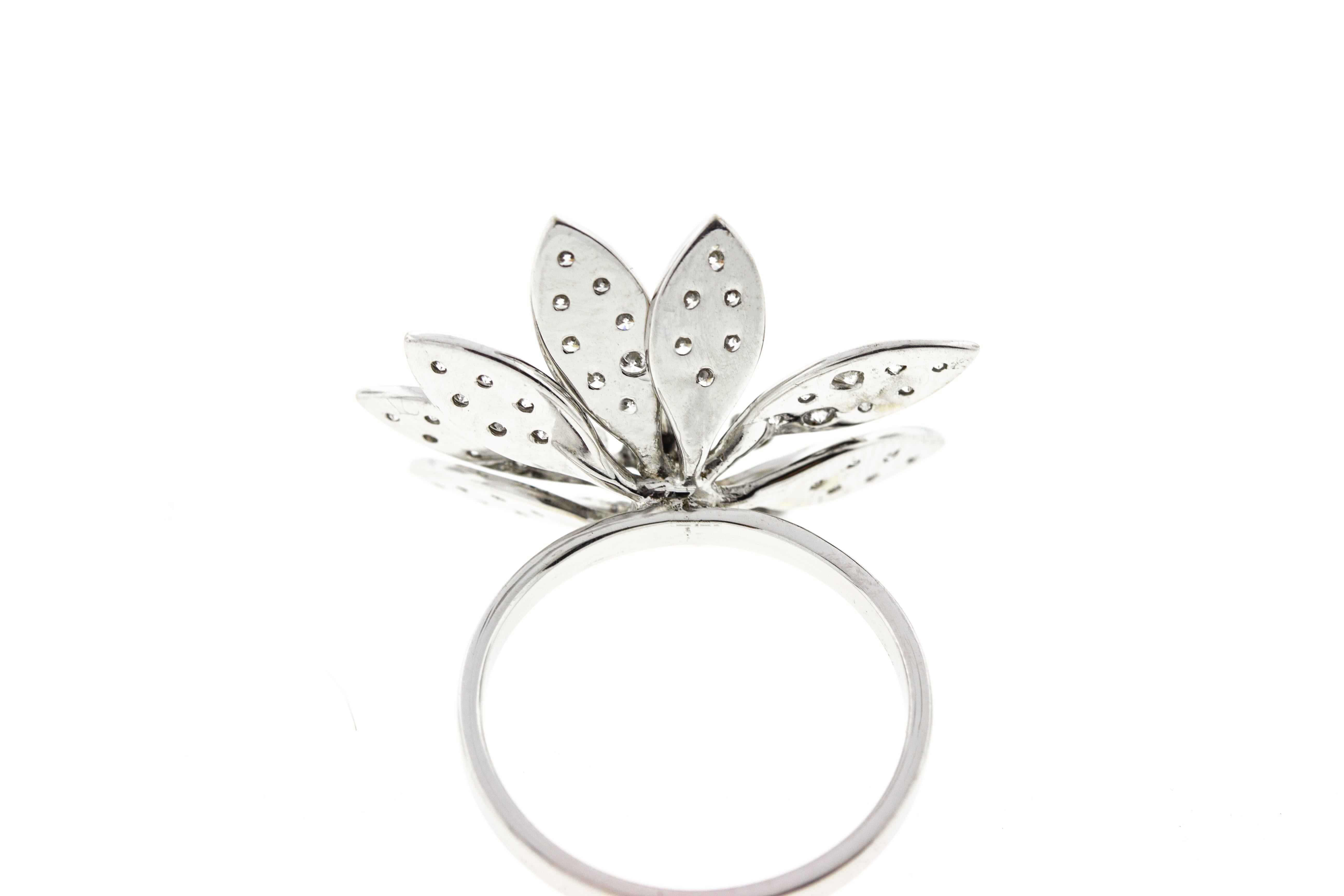 This vintage style floral cocktail ring is made in white gold and features diamonds on the leaves and petals.  A total carat weight of .56 diamonds are encrusted on the ring's petals. 