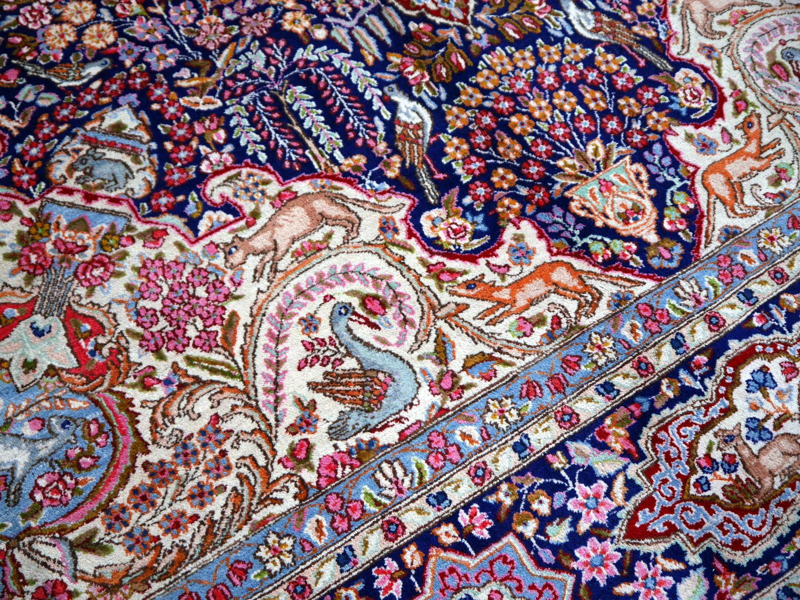 A fine, hand knotted vintage rug with traditional Oriental floral hunting design. Size 13 x 10 ft / 400 x 300 cm.

This stunning rug has vibrant colors and a decorative design with rich motifs. Flowers, lions, deer and arabesques are filling the