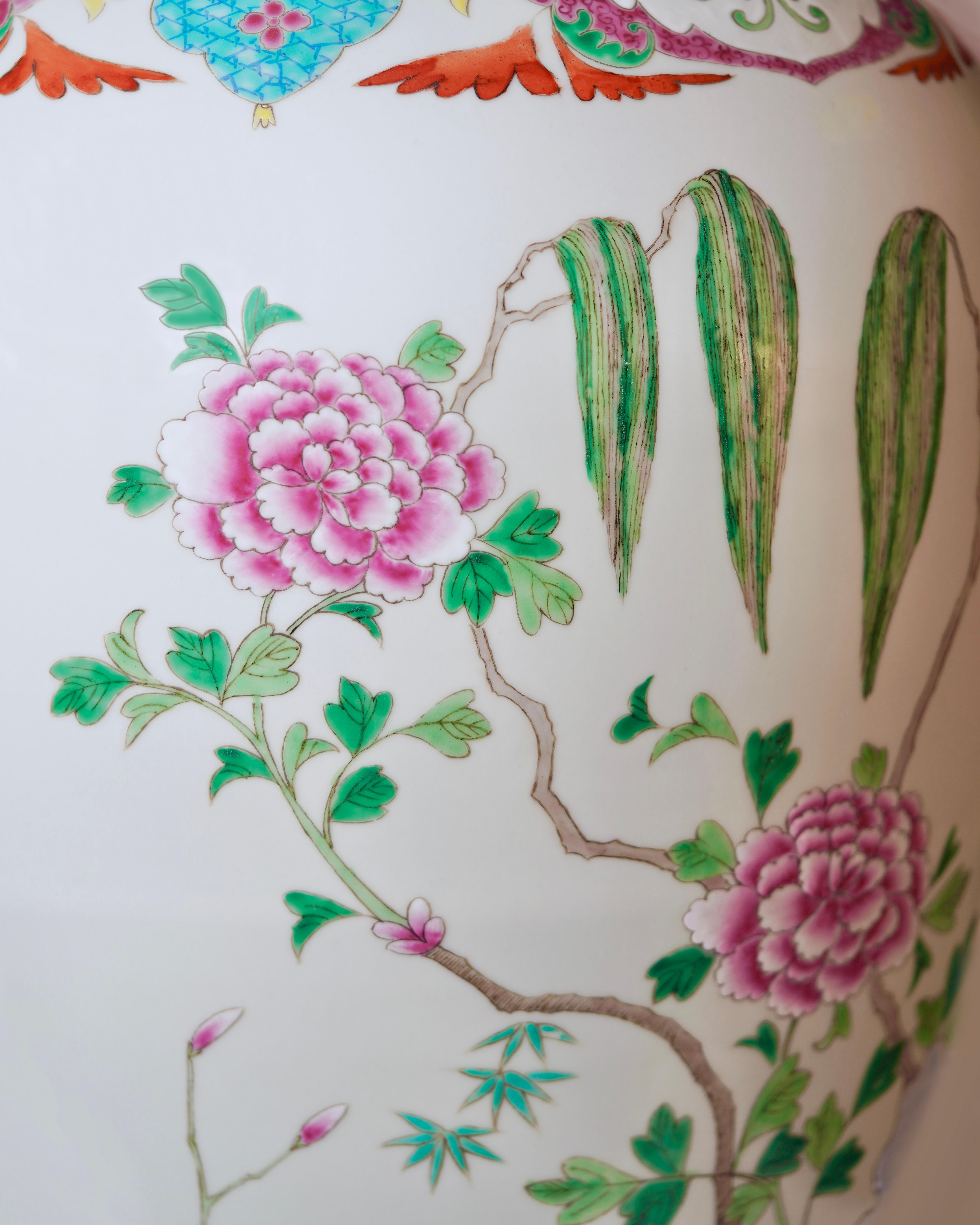 Ce grand vase de sol vintage est un récipient traditionnel en porcelaine provenant de Towneshen, une ville longtemps distinguée par le patronage impérial. Les gerbes vivantes peintes à la main et la verdure tropicale complètent les éléments