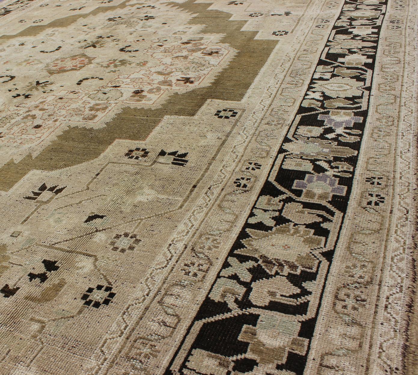 Measures: 8'0 x 11'0

This vintage Turkish Oushak carpet (circa mid-20th century) features a central, multi-layered medallion design, as well as patterns of smaller flowers and floral elements in the four cornices, and in the surrounding borders.