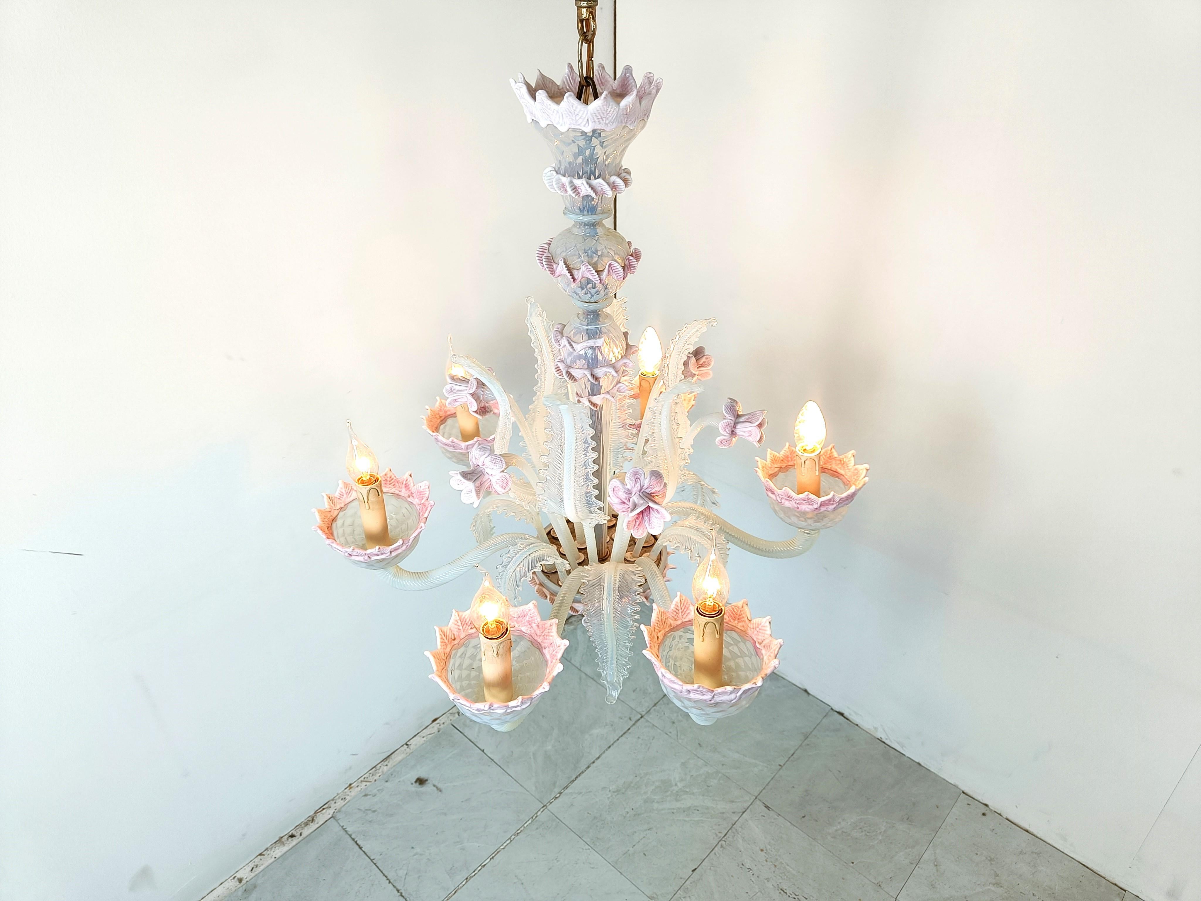 Superbe lustre en verre de Murano datant du milieu du siècle dernier.

Il se compose de 6 bras avec des lampes candélabres.

Le lustre est très élégant et comporte de magnifiques fleurs et feuilles faites à la main.

Complet et en bon état, testé et