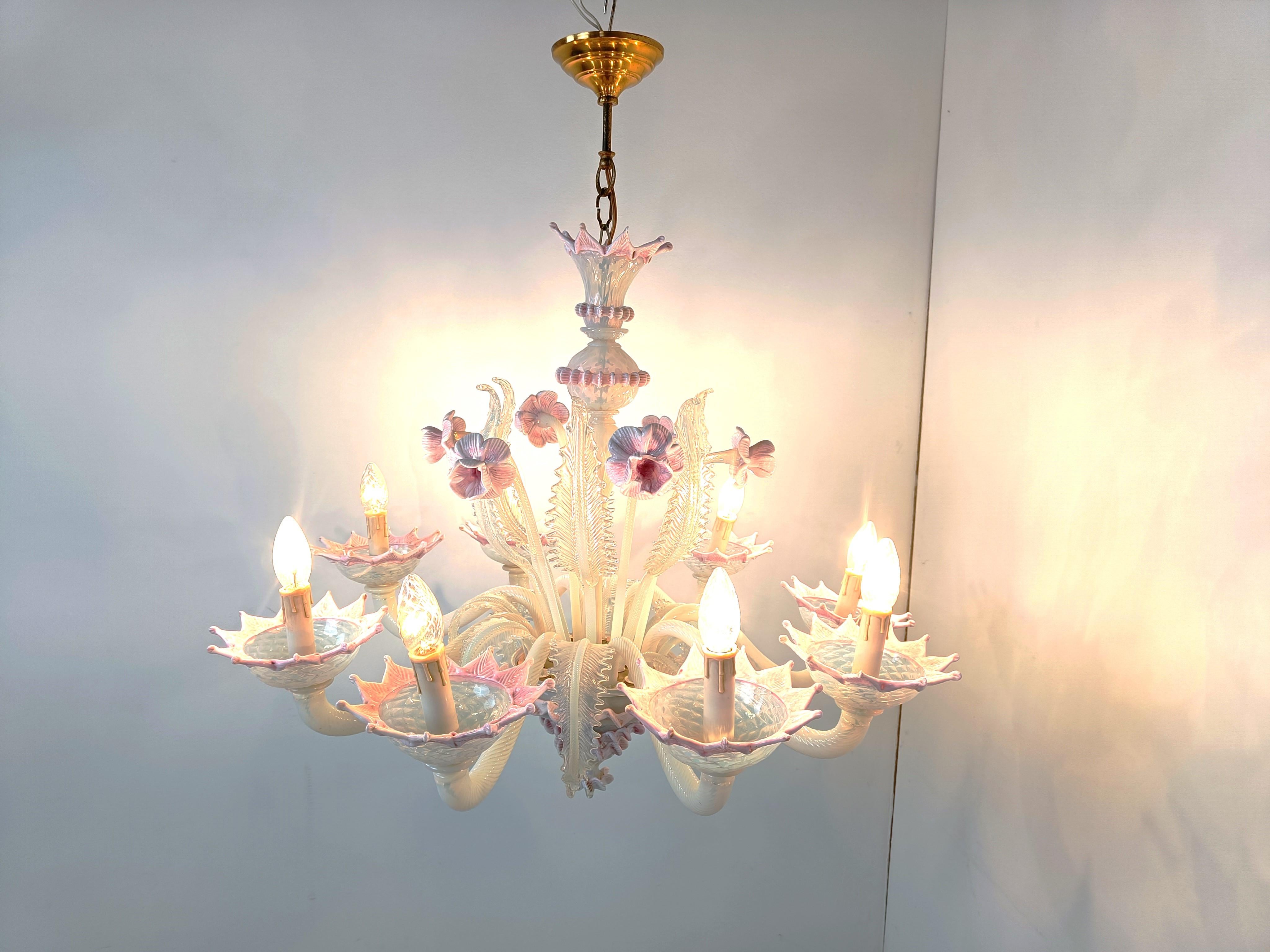 Superbe lustre en verre de Murano datant du milieu du siècle dernier.

Il se compose de 8 bras avec des lampes candélabres.

Le lustre est très élégant et comporte de magnifiques fleurs et feuilles faites à la main.

Complet et en bon état, testé et