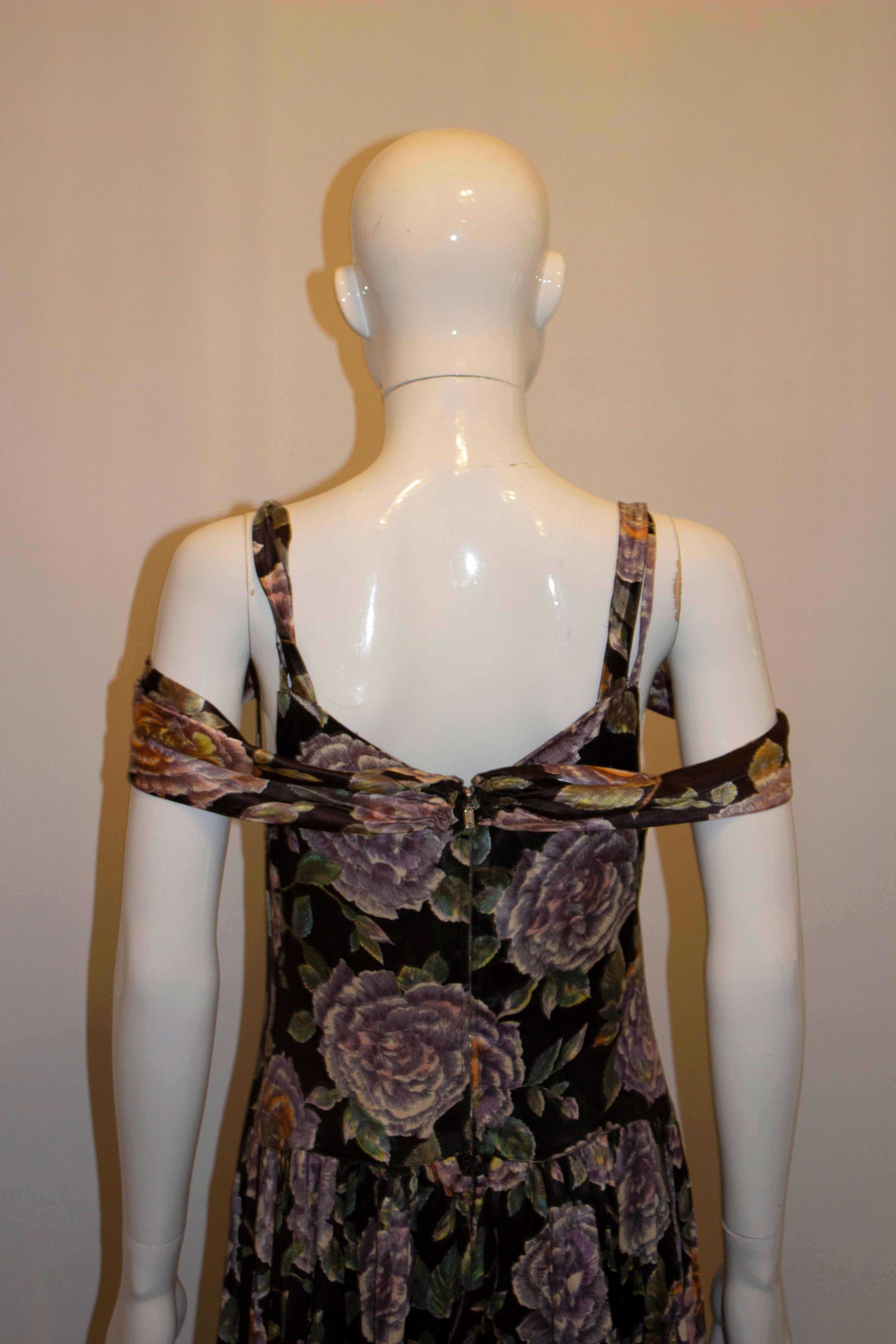 A pretty and easy to wear evening dress in a floral print.  The dress has a black background, back central zip and shoulder straps. It is unlined. 