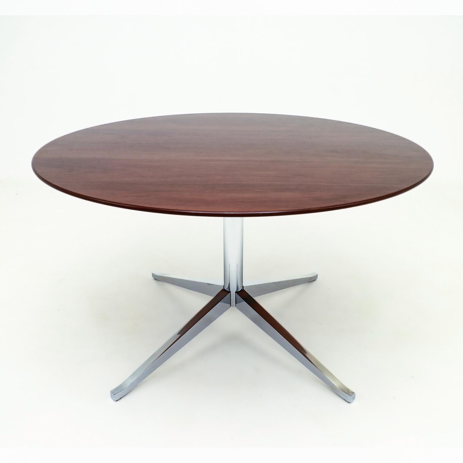 Vintage circular Walnut and chrome Florence Knoll pedestal dining or conference table.

This table is a classic Florence Knoll Walnut table with a heavy four star chrome pedestal base and maintains the original adjustable floor glides. The design