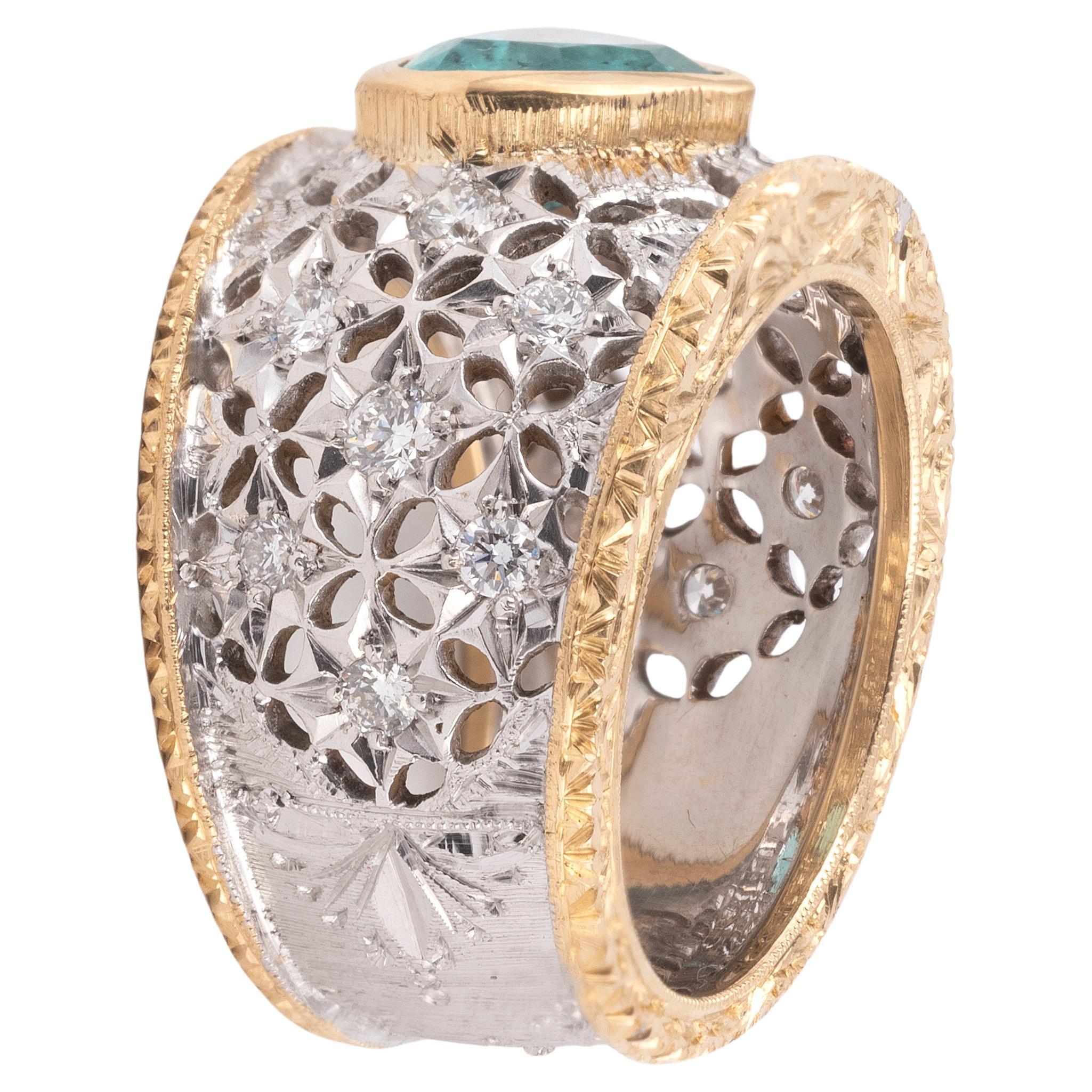 Este anillo vintage de diamantes y una esmeralda presenta un acabado florentino y está centrado con una esmeralda en forma de corazón de aproximadamente 1,6 ct que está empotrada en el centro del anillo. Los hombros del anillo están acentuados con
