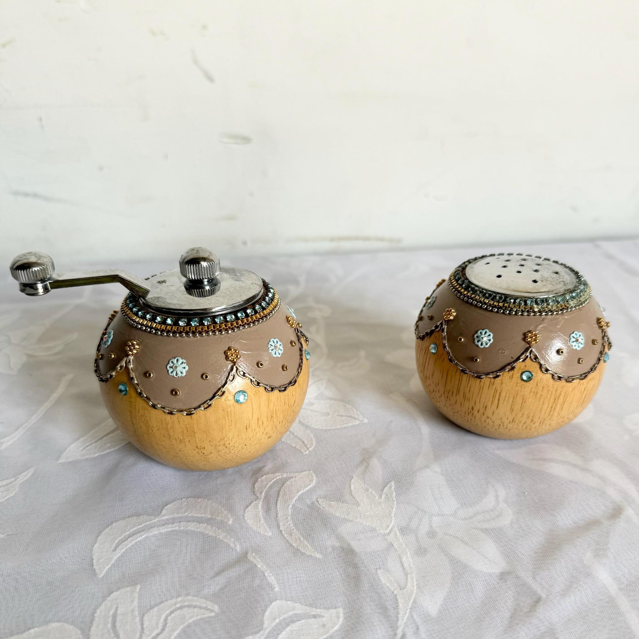 Cet ensemble salière et moulin à poivre Florentine vintage présente d'élégants détails dessinés à la main. La finition ornée or et blanc ajoute une touche de sophistication européenne à toute table à manger ou cuisine. Parfait pour ceux qui