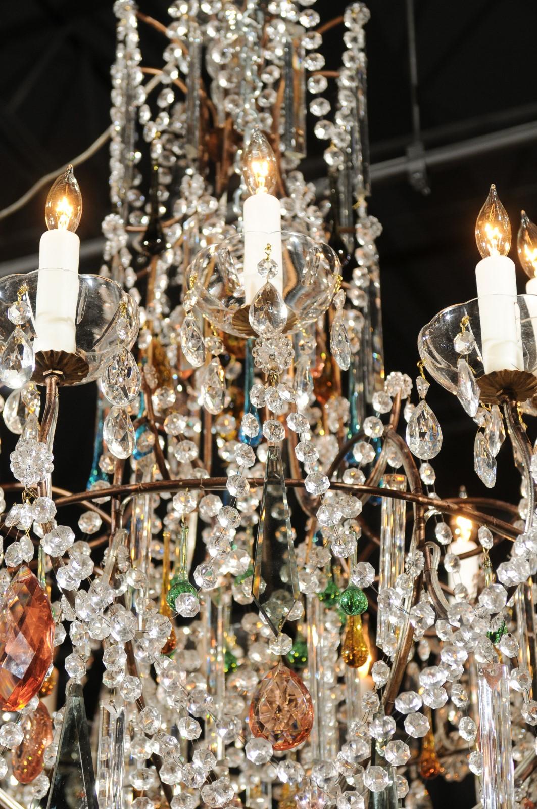 An Italian vintage crystal 16-light chandelier from Florence with colorful crystals. Born in Florence during the midcentury period, this stunning crystal chandelier features a discreet metal armature supporting an abundance of crystals of various